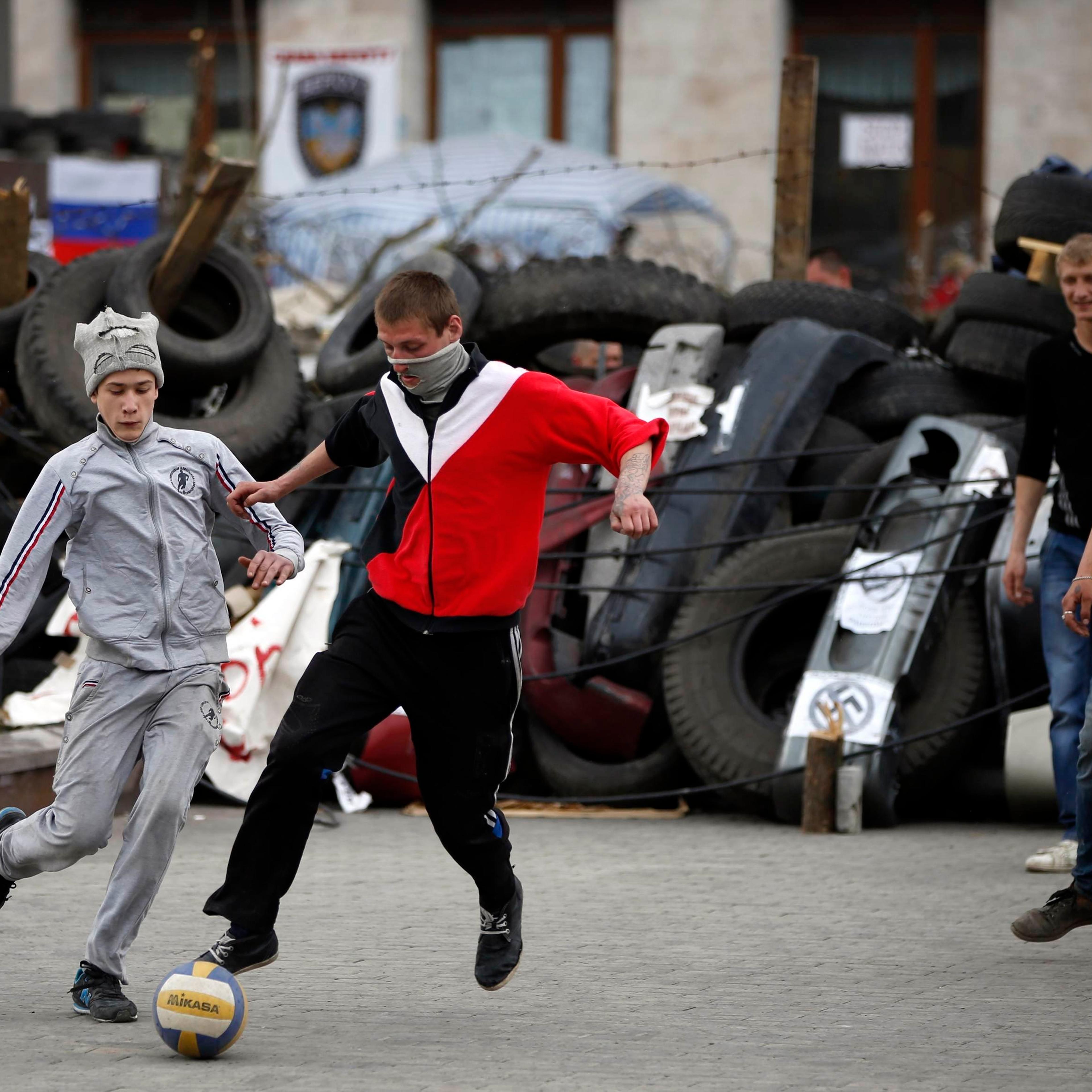 Pro-Russian protesters play soccer in front of a barricade outside a regional government building in Donetsk, eastern Ukraine April 19, 2014.