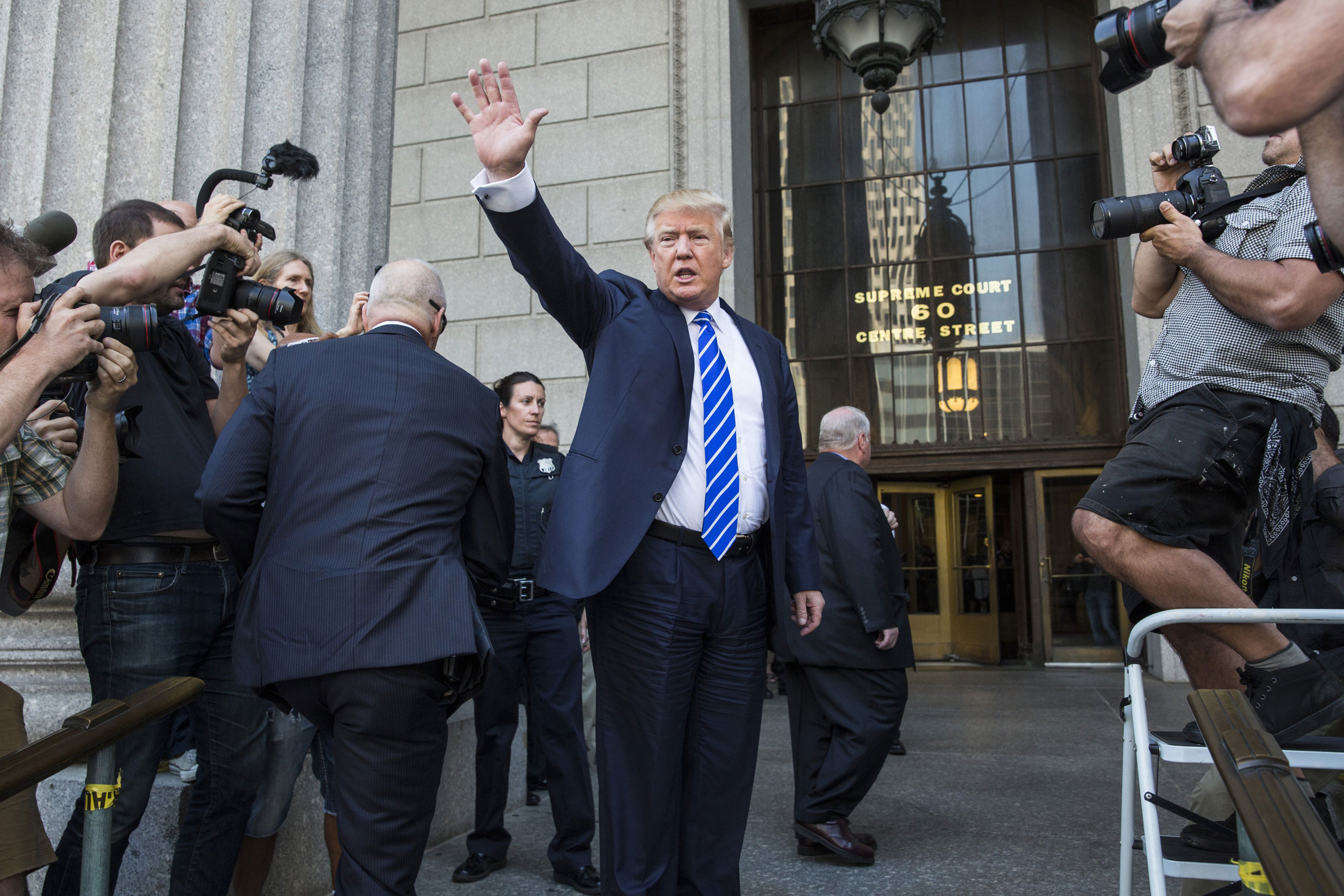 NEW YORK, NY - AUGUST 17: Republican Presidential hopeful Donald Trump waves as he arrives at U.S. Federal Court to report for jury duty on August 17, 2015 in New York City. Trump spent the last few days on the campaign trail at the Iowa state fair befor