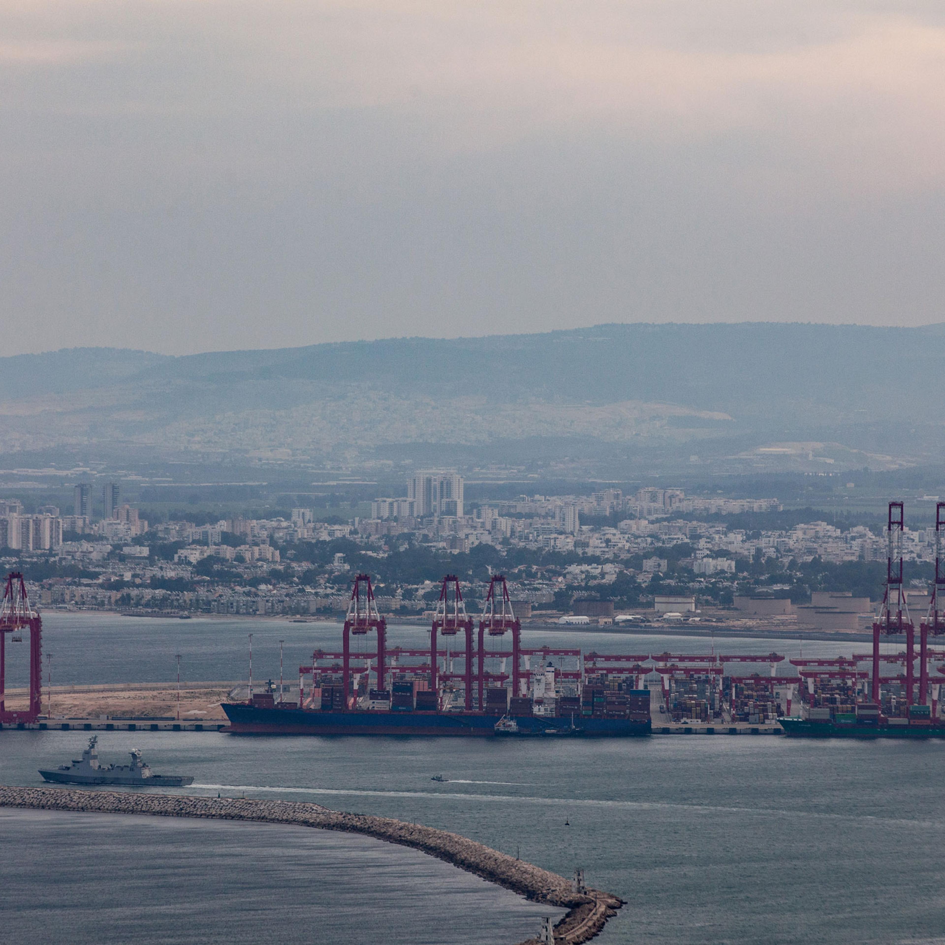 Commercial ships and an Israeli naval vessel are seen in the port city of Haifa