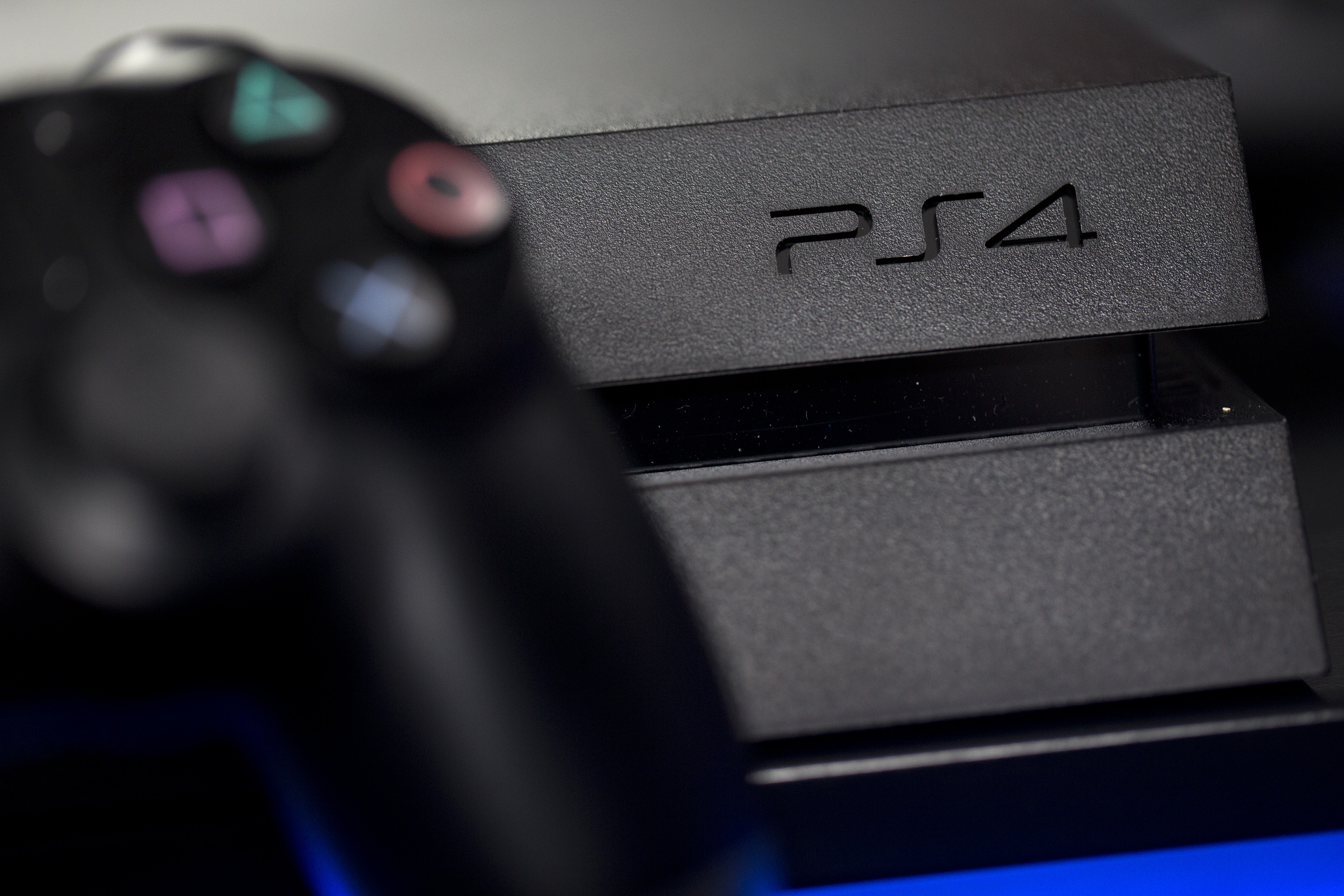 A logo sits on the front of a Sony PlayStation 4 (PS4) games console, manufactured by Sony Corp., in this arranged photograph taken in London on Nov. 15, 2013