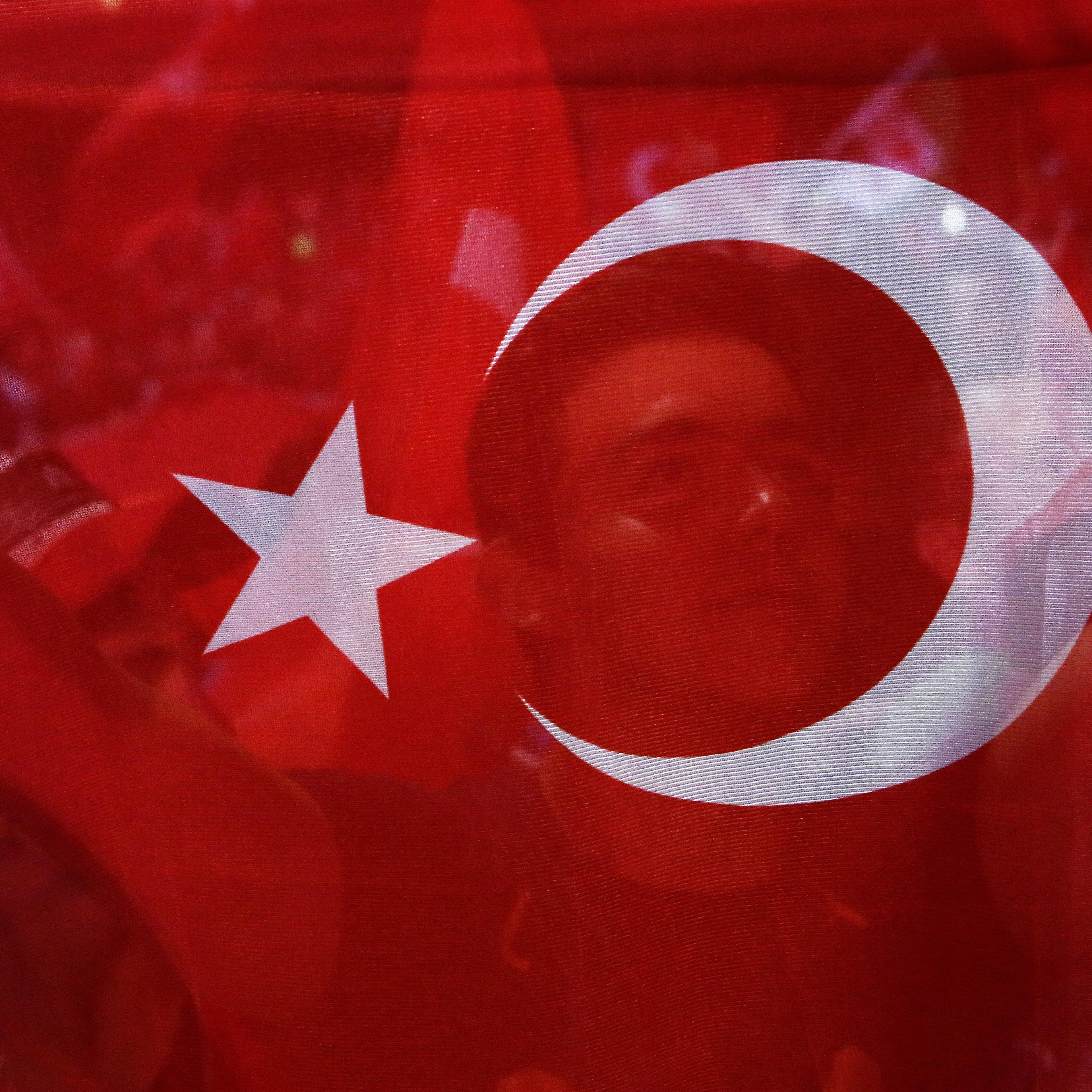 A man holds a Turkish flag during an anti coup rally at Taksim square in Istanbul, on July 26, 2016.