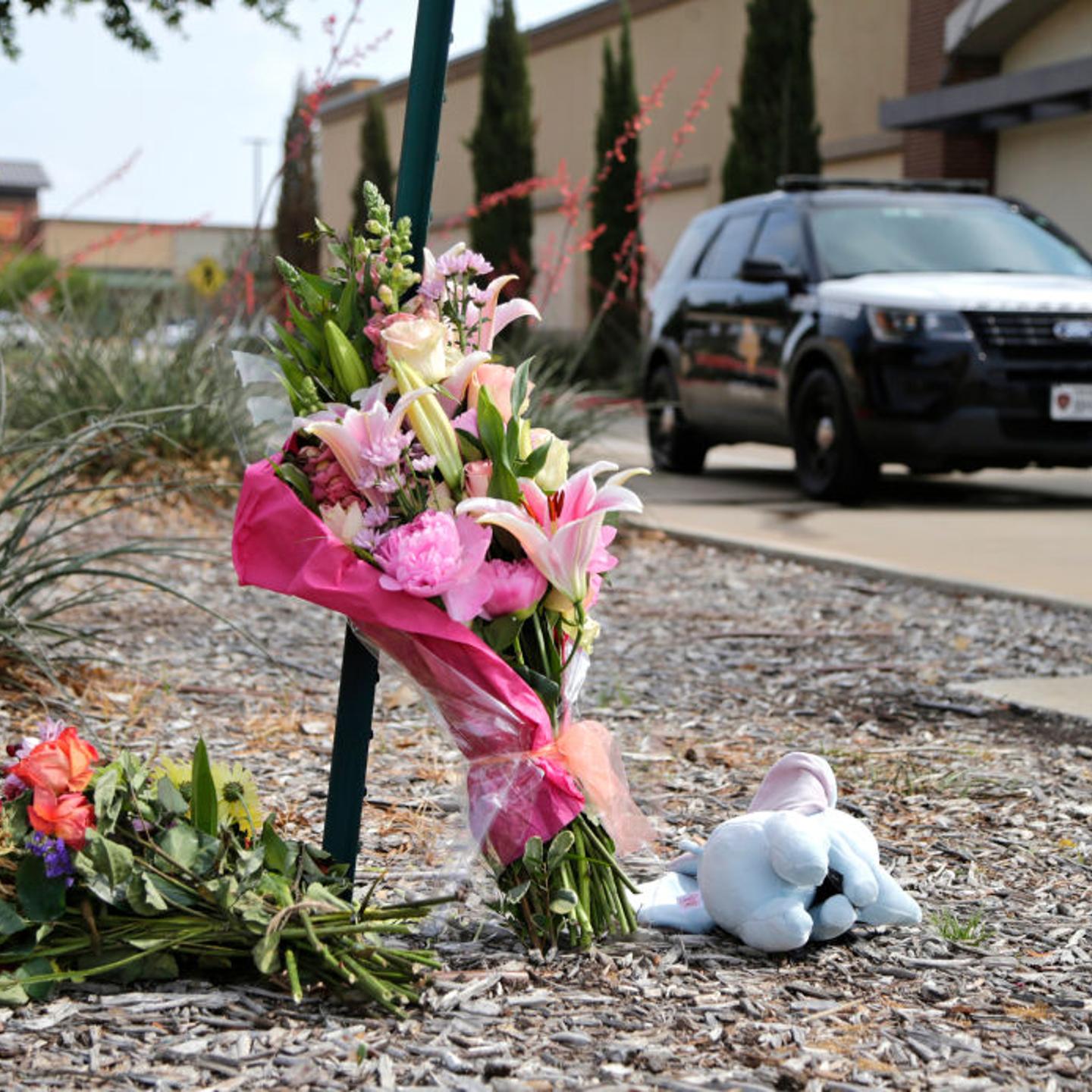 Flowers and a stuffed animal are left at the scene the day after a shooting at Allen Premium Outlets in Allen, Texas