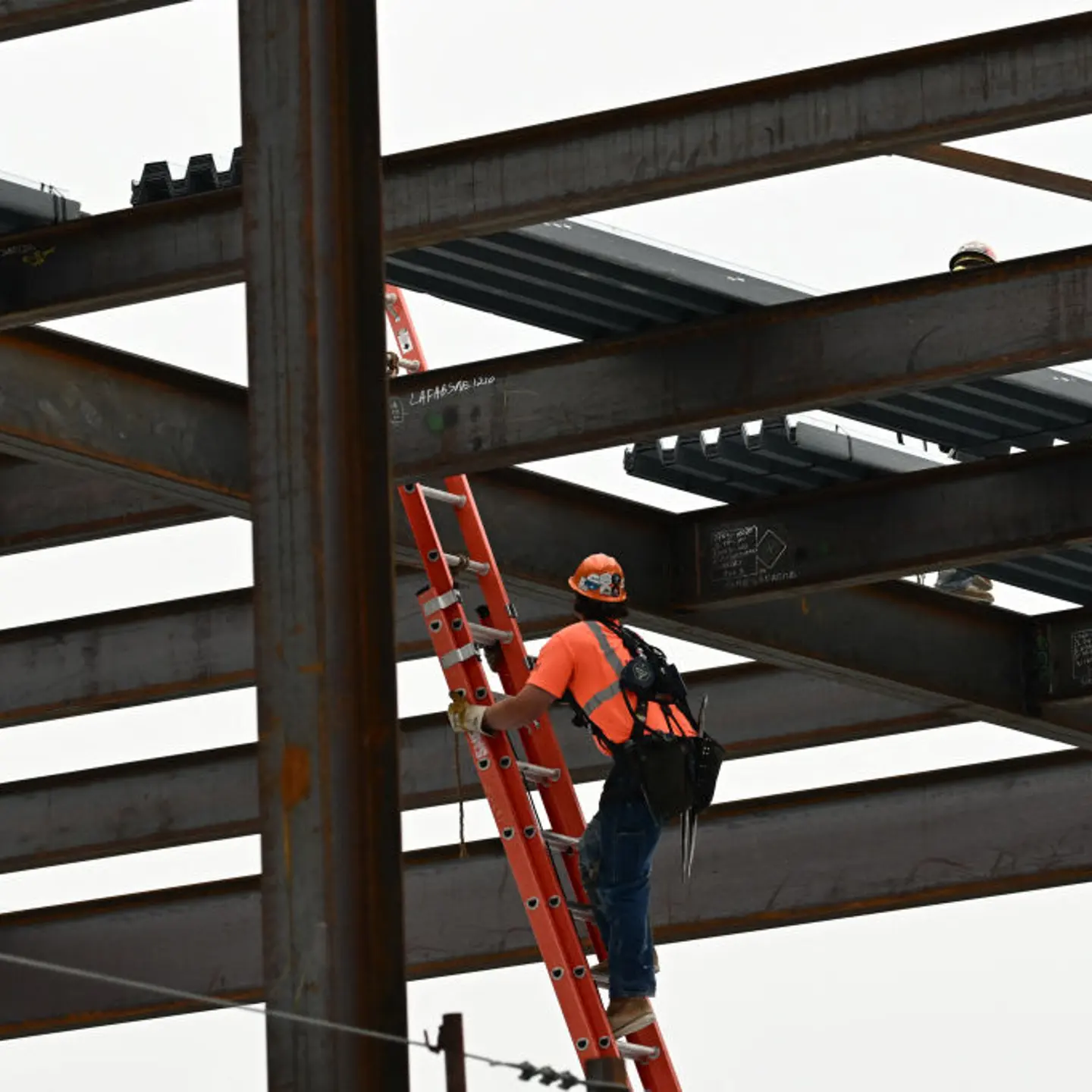 A construction worker climbs a ladder at LAX airport.