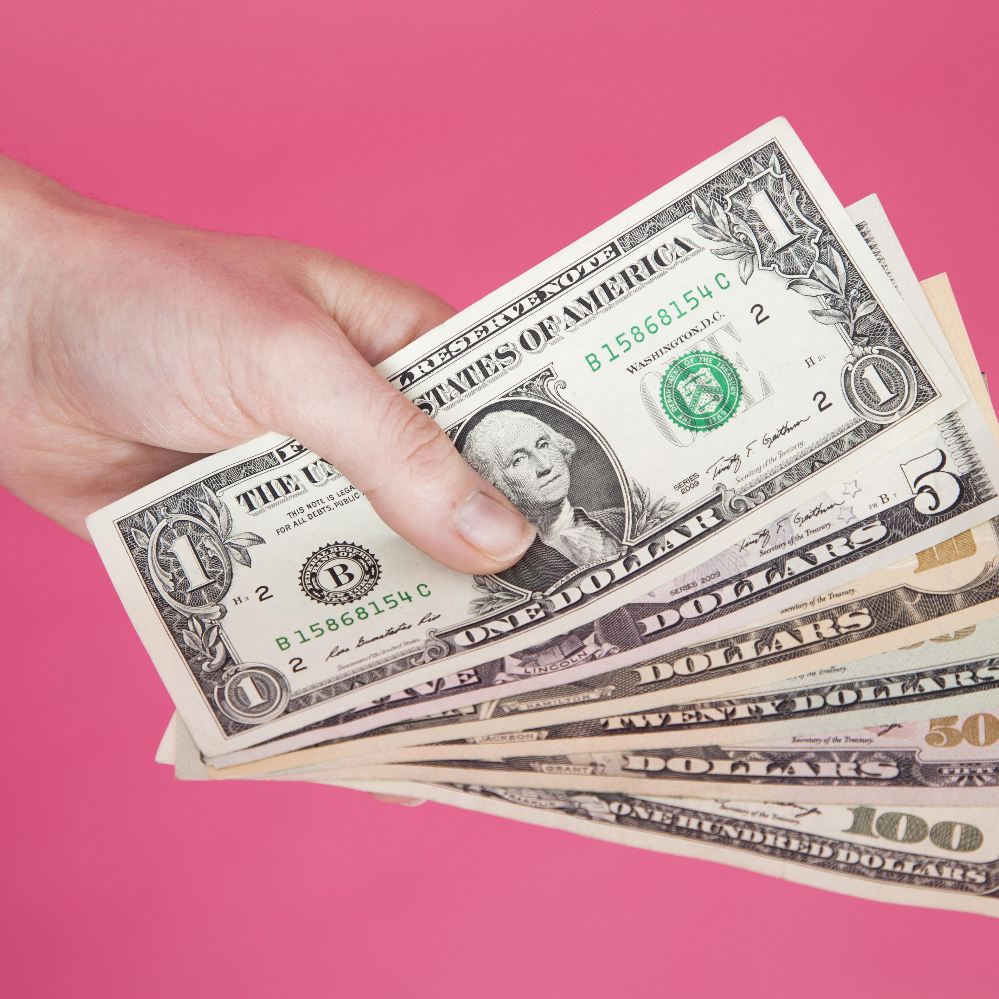Woman's hand holding US banknotes