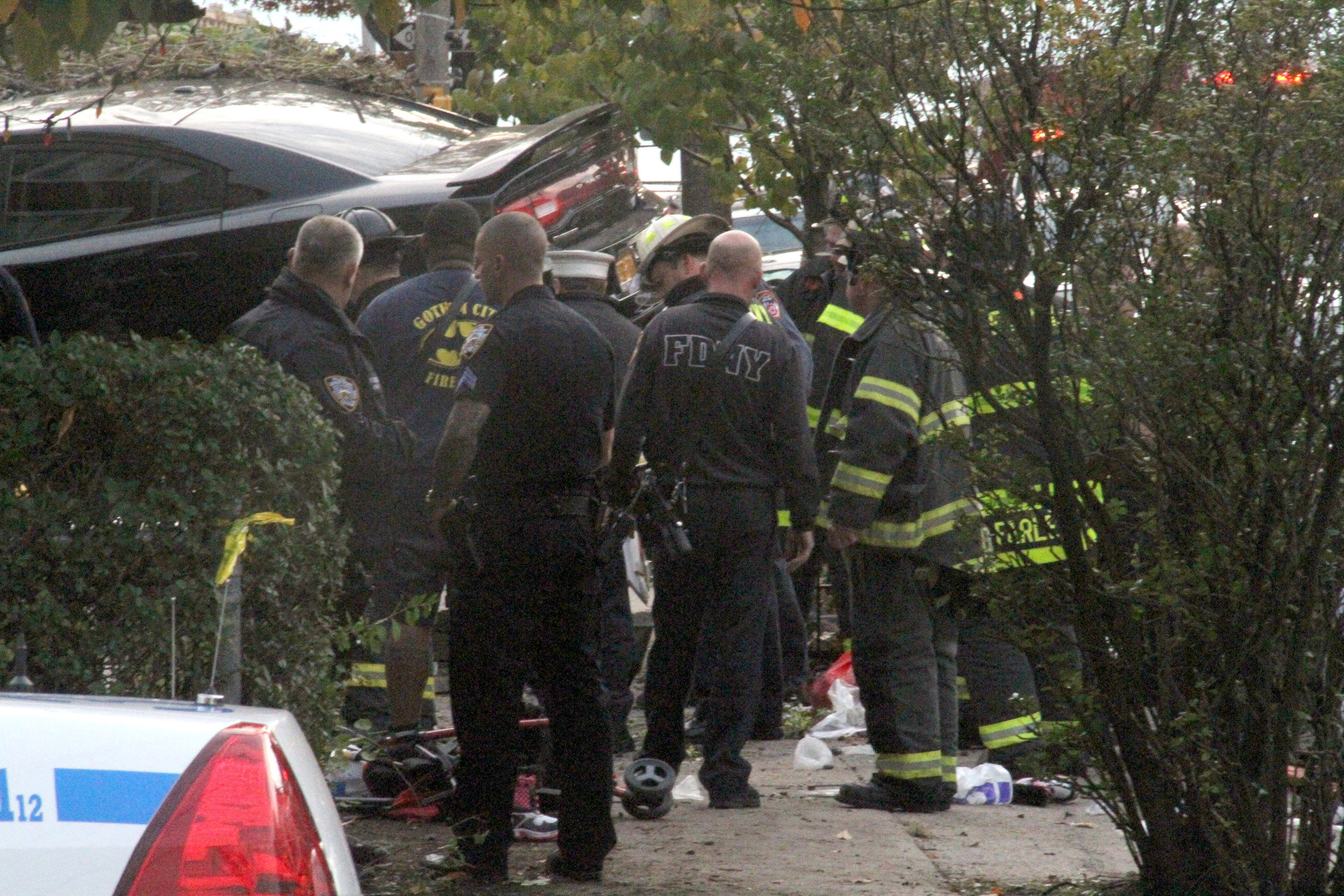 First responders examine an automobile after its driver lost control and plowed into a group of trick-or-treaters Saturday, Oct. 31, 2015 in New York. Three people were killed in the, including a 10-year-old girl. Several others were injured. (AP Photo/D