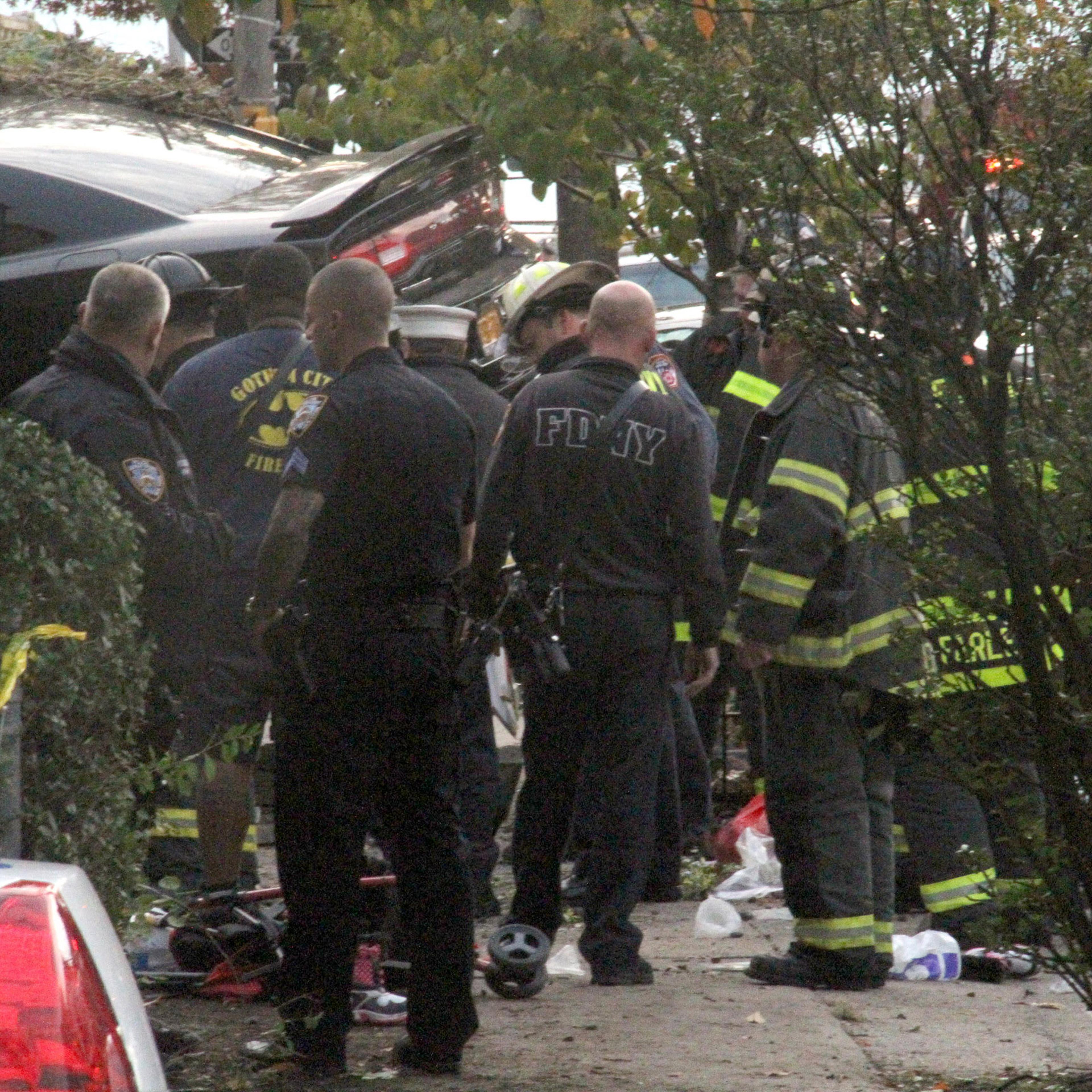 First responders examine an automobile after its driver lost control and plowed into a group of trick-or-treaters Saturday, Oct. 31, 2015 in New York. Three people were killed in the, including a 10-year-old girl. Several others were injured. (AP Photo/D