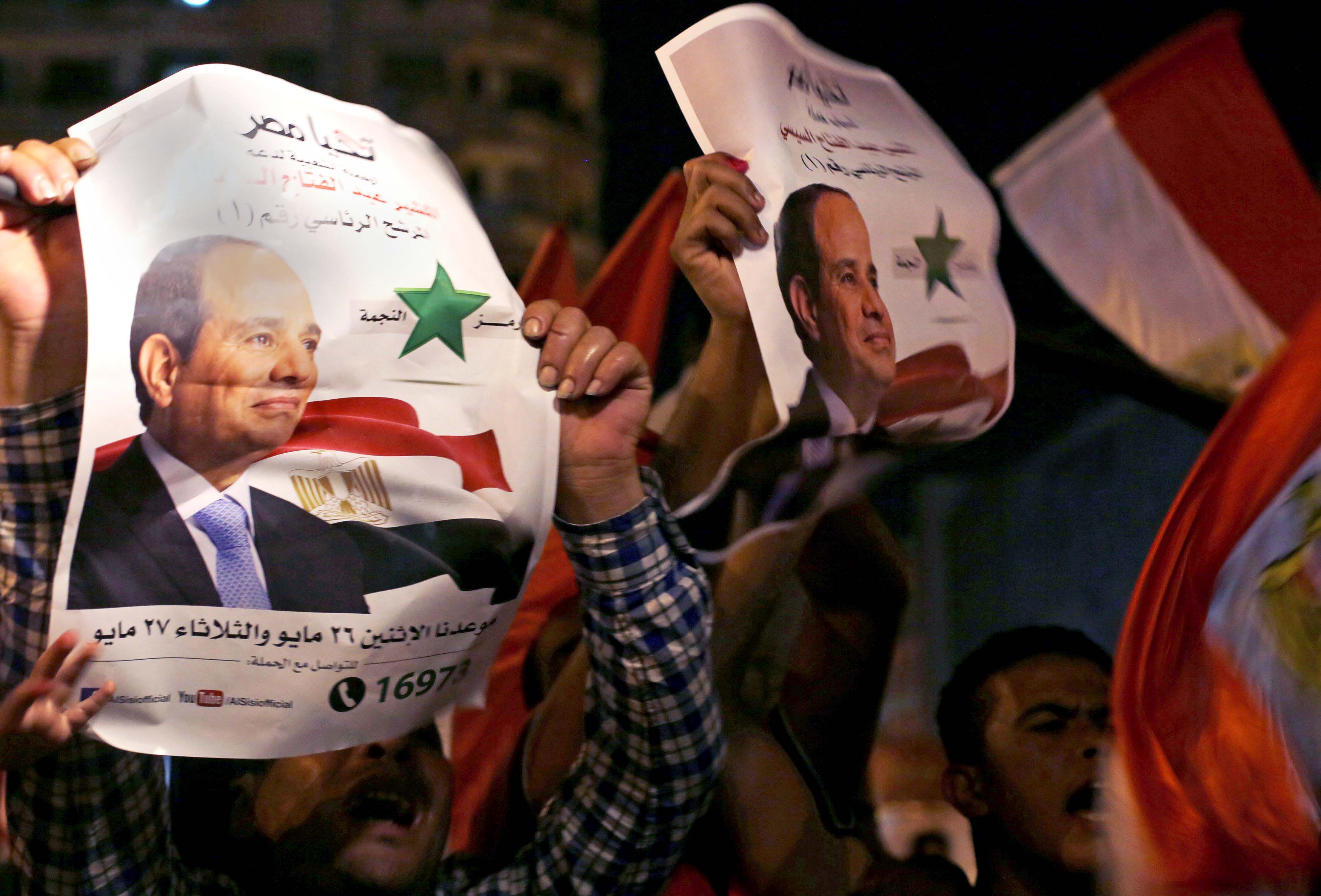 Supporters hold up posters of Egypt's former army chief Abdel Fattah al-Sisi as they celebrate at Tahrir square in Cairo May 28, 2014.