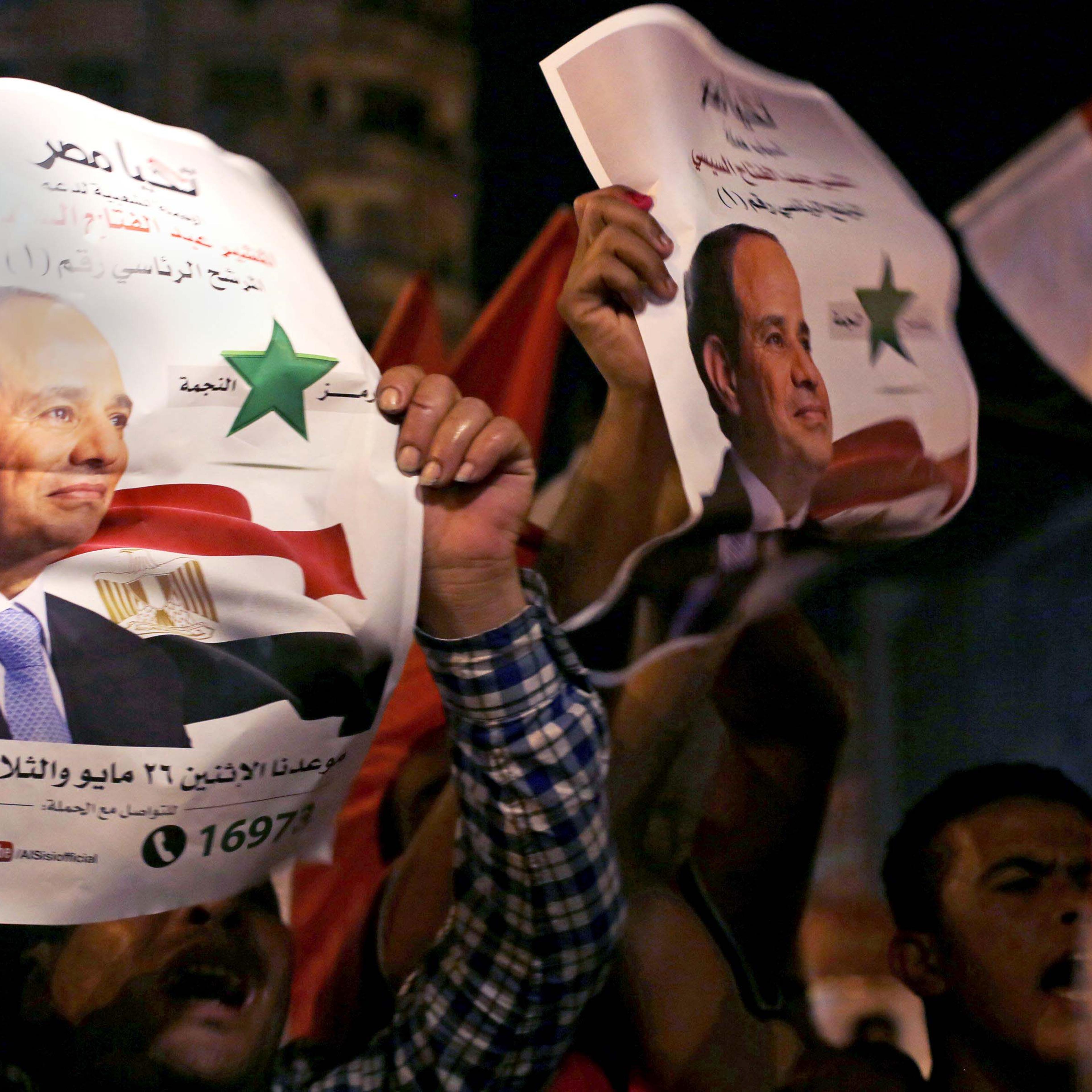 Supporters hold up posters of Egypt's former army chief Abdel Fattah al-Sisi as they celebrate at Tahrir square in Cairo May 28, 2014.
