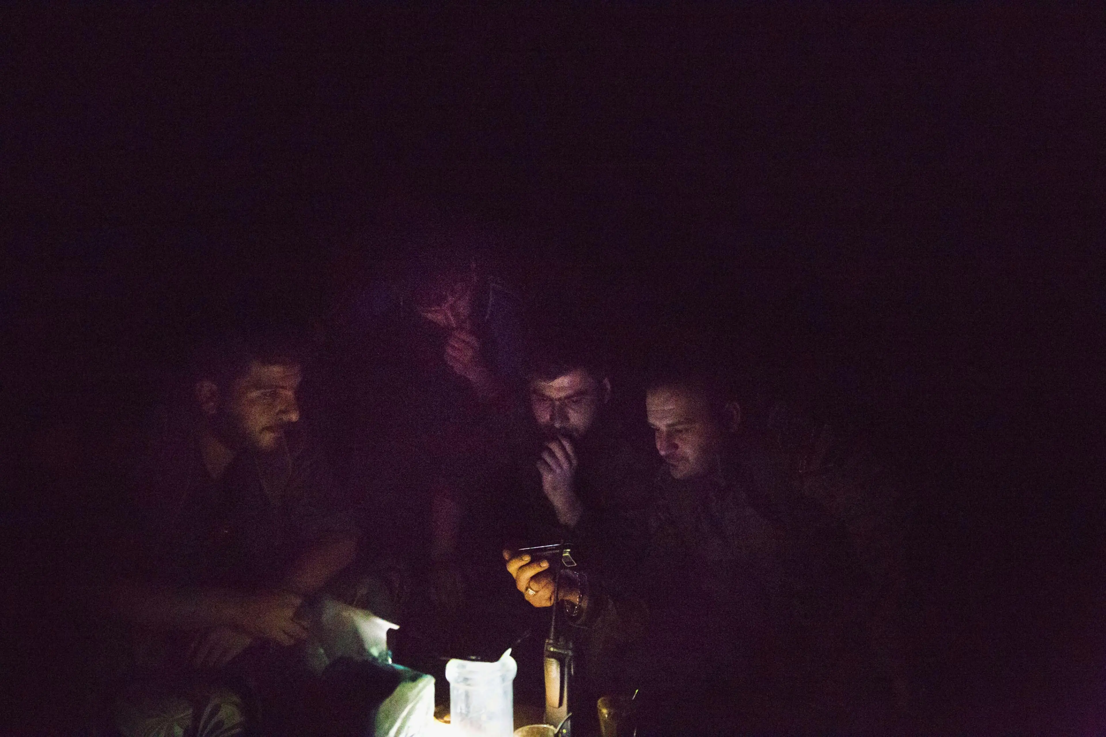 Deep inside the industrial district of Deir-ez Zor, close to known ISIS positions, fighters with the Syrian government's Directorate of Military Intelligence watch a video on a cellphone, May 16, 2015.