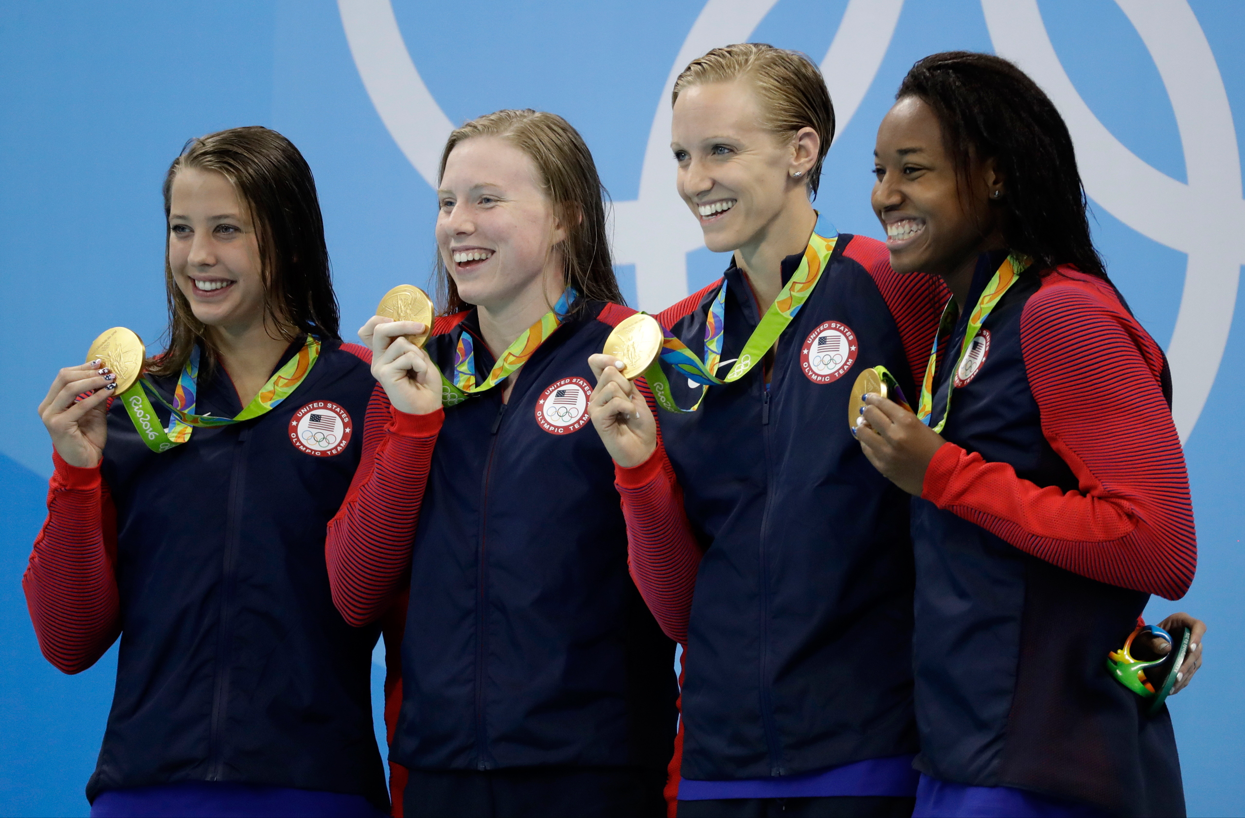 From left to right, United States' Kathleen Baker, Lilly King, Dana Vollmer and Simone Manuel display their gold medals for the women's 4 x 100-meter medley relay final during the swimming competitions at the 2016 Summer Olympics, Saturday, Aug. 13, 2016