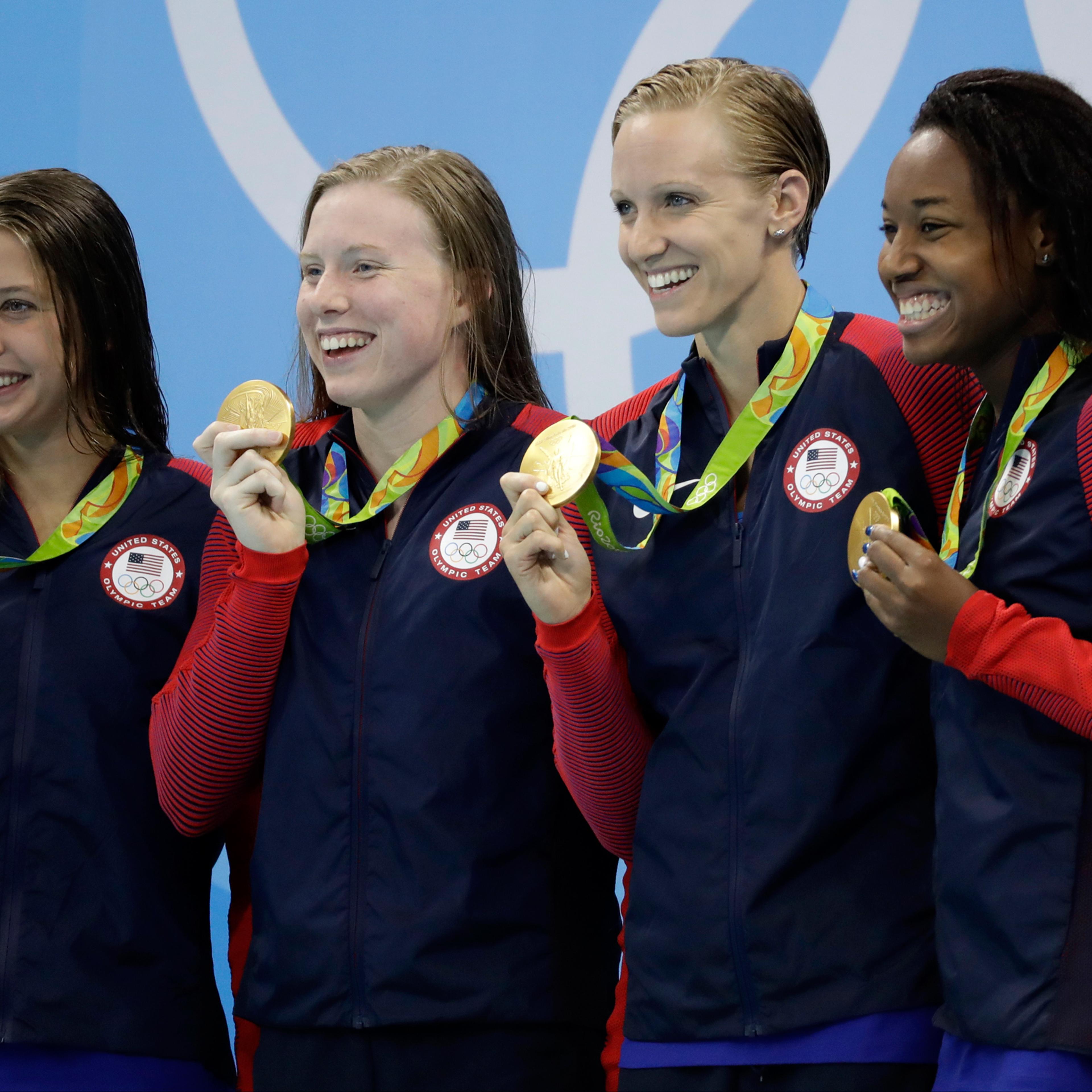 From left to right, United States' Kathleen Baker, Lilly King, Dana Vollmer and Simone Manuel display their gold medals for the women's 4 x 100-meter medley relay final during the swimming competitions at the 2016 Summer Olympics, Saturday, Aug. 13, 2016