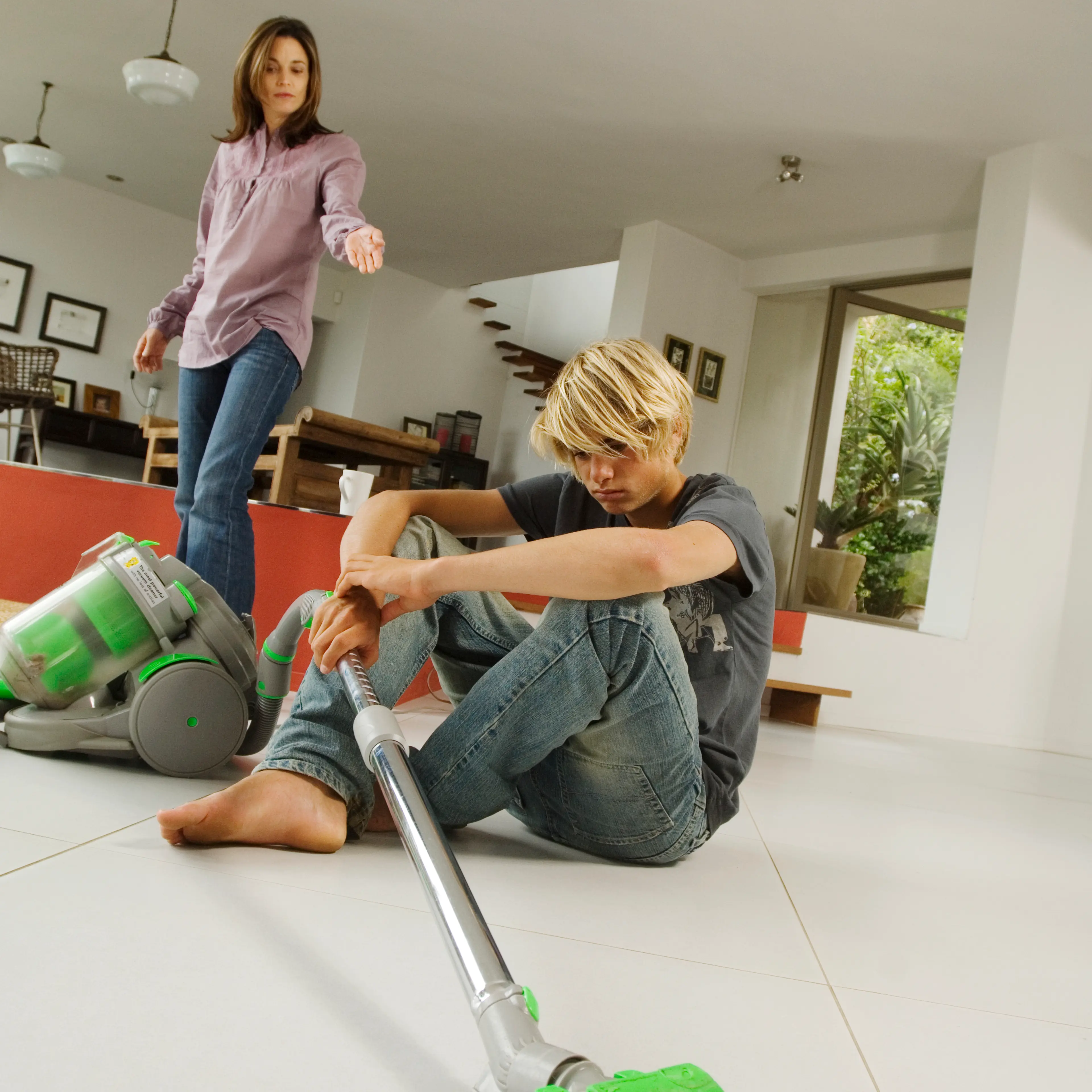 Mother and son in living room, vacuum cleaner, indoors