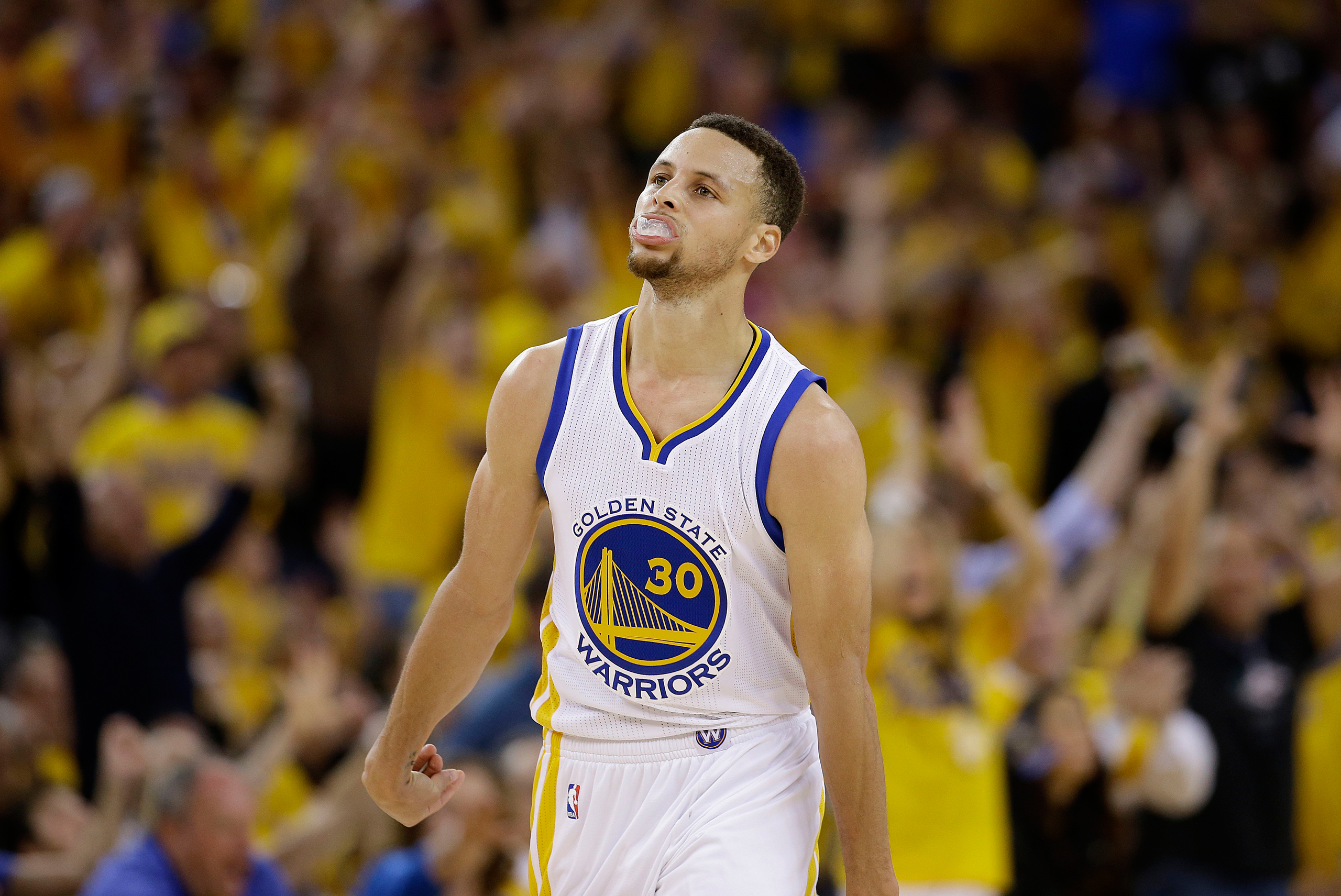 Golden State Warriors guard Stephen Curry (30) reacts after scoring against the Oklahoma City Thunder during the first half of Game 1 of the NBA basketball Western Conference finals in Oakland, Calif., Monday, May 16, 2016. (AP Photo/Marcio Jose Sanchez)