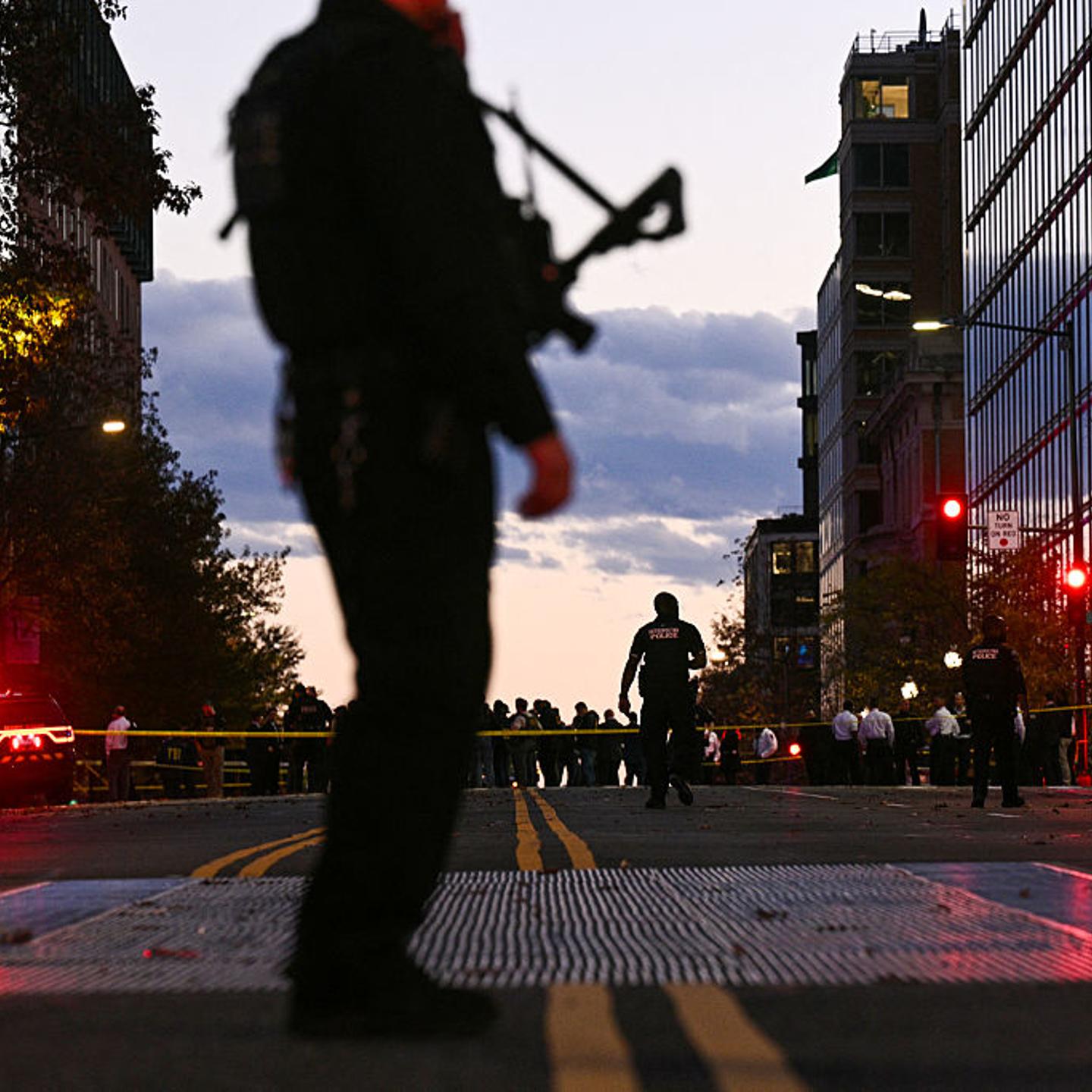 A police officer secures the area as law-enforcement officials visit the crime scene of a shooting in downtown Washington, DC, on Nov. 26, 2025.