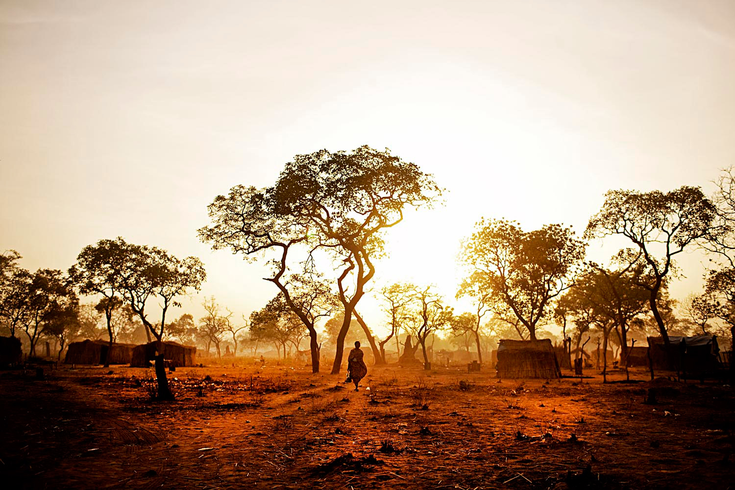 A refugee from the Nuba Mountains wanders through the Yida refugee camp at dawn. People try to accomplish tasks early in the day before the heat sets in. 