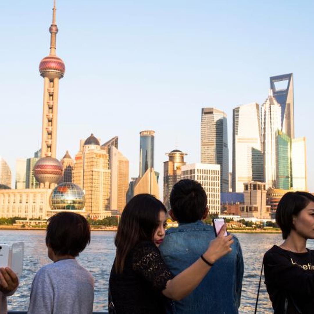 Tourists are taking selfies with the Oriental Pearl tower on