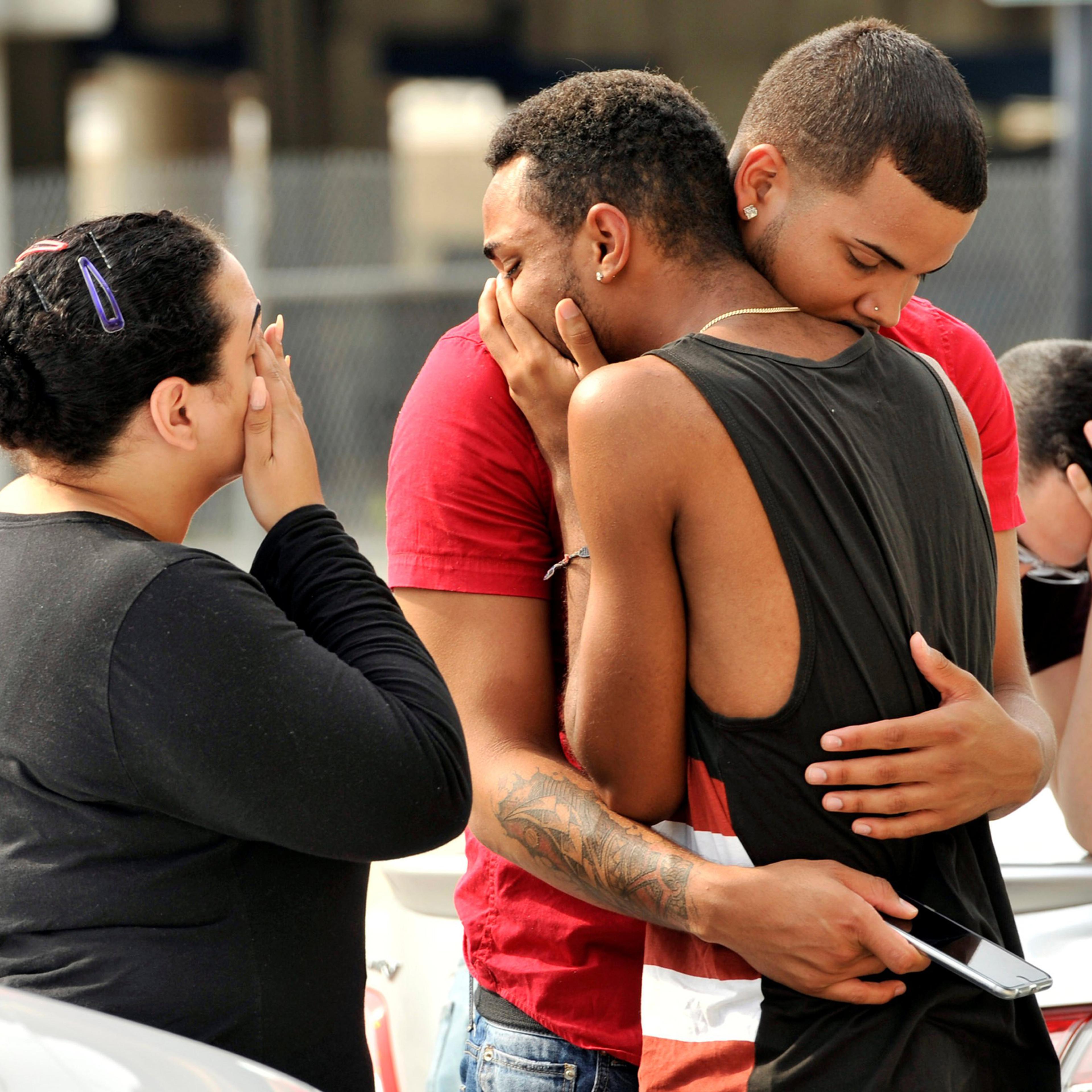 Friends and family members embrace outside the Orlando Police Headquarters during the investigation of a shooting at the Pulse nightclub in Orlando, Fla., on June 13, 2016.