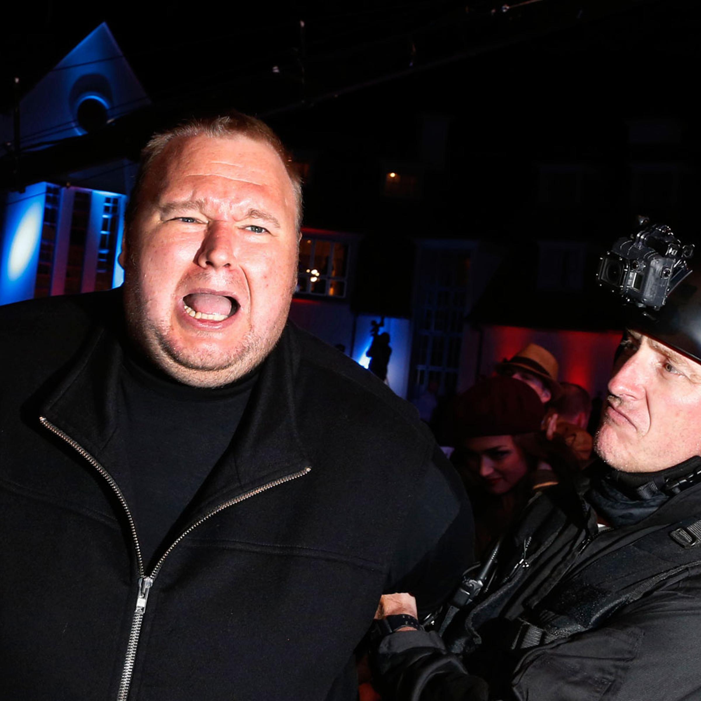An actor in police costume mock-arrests Megaupload founder Kim Dotcom, left, as he launches his new file sharing site "Mega" in Auckland Jan. 20, 2013.