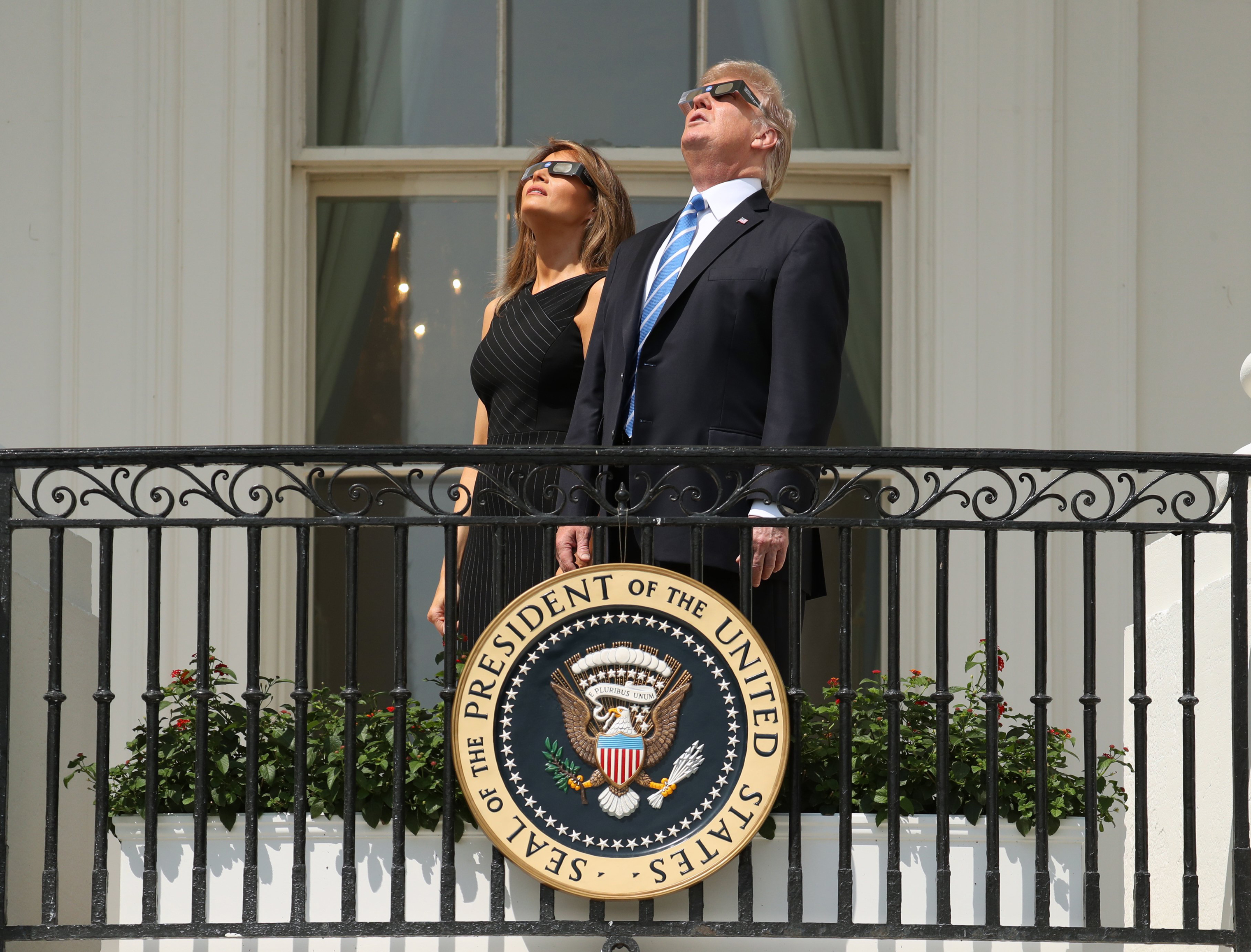 President Trump and First Lady Melania Trump wear protective glasses as they view the solar eclipse at the White House in Washington on Aug. 21, 2017.