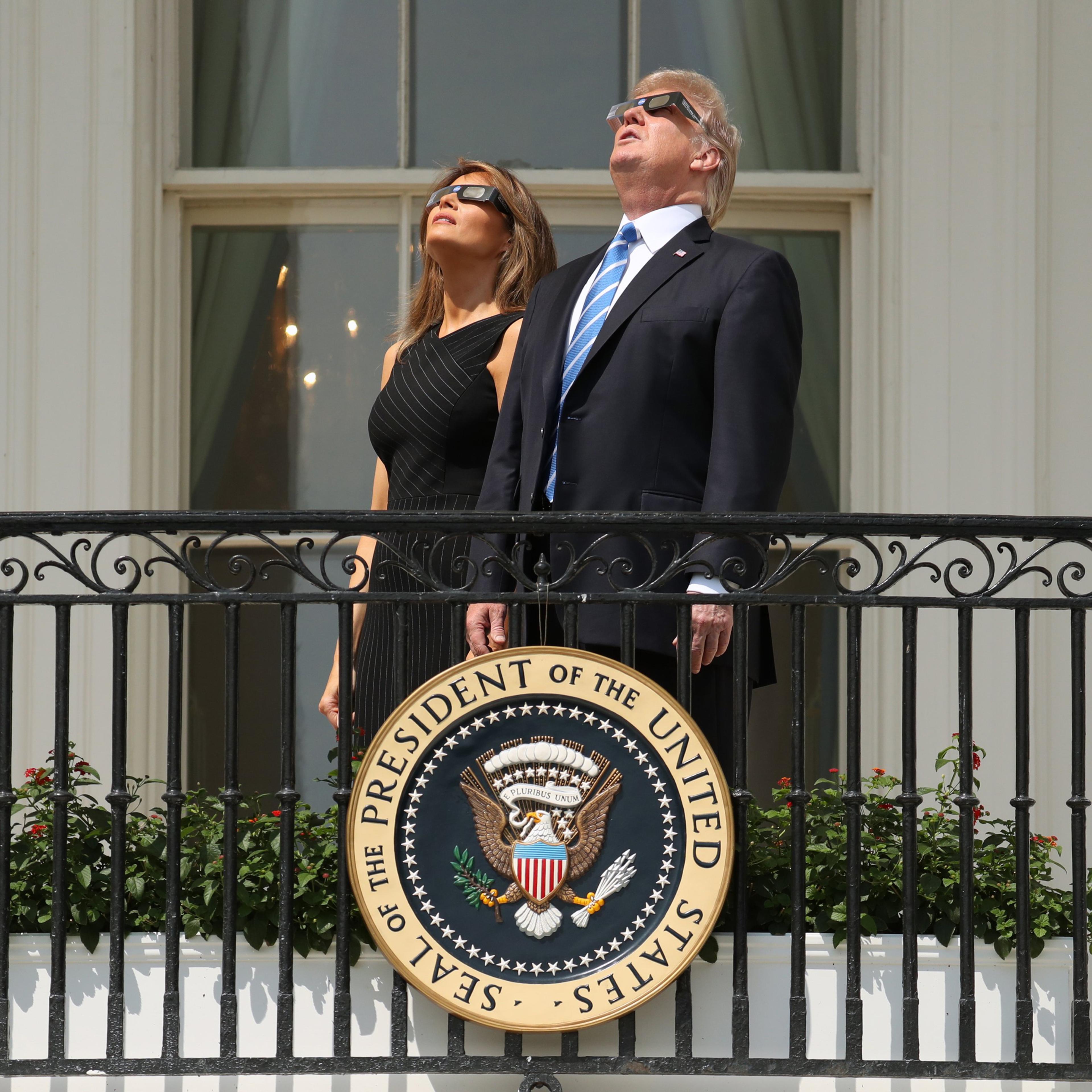 President Trump and First Lady Melania Trump wear protective glasses as they view the solar eclipse at the White House in Washington on Aug. 21, 2017.
