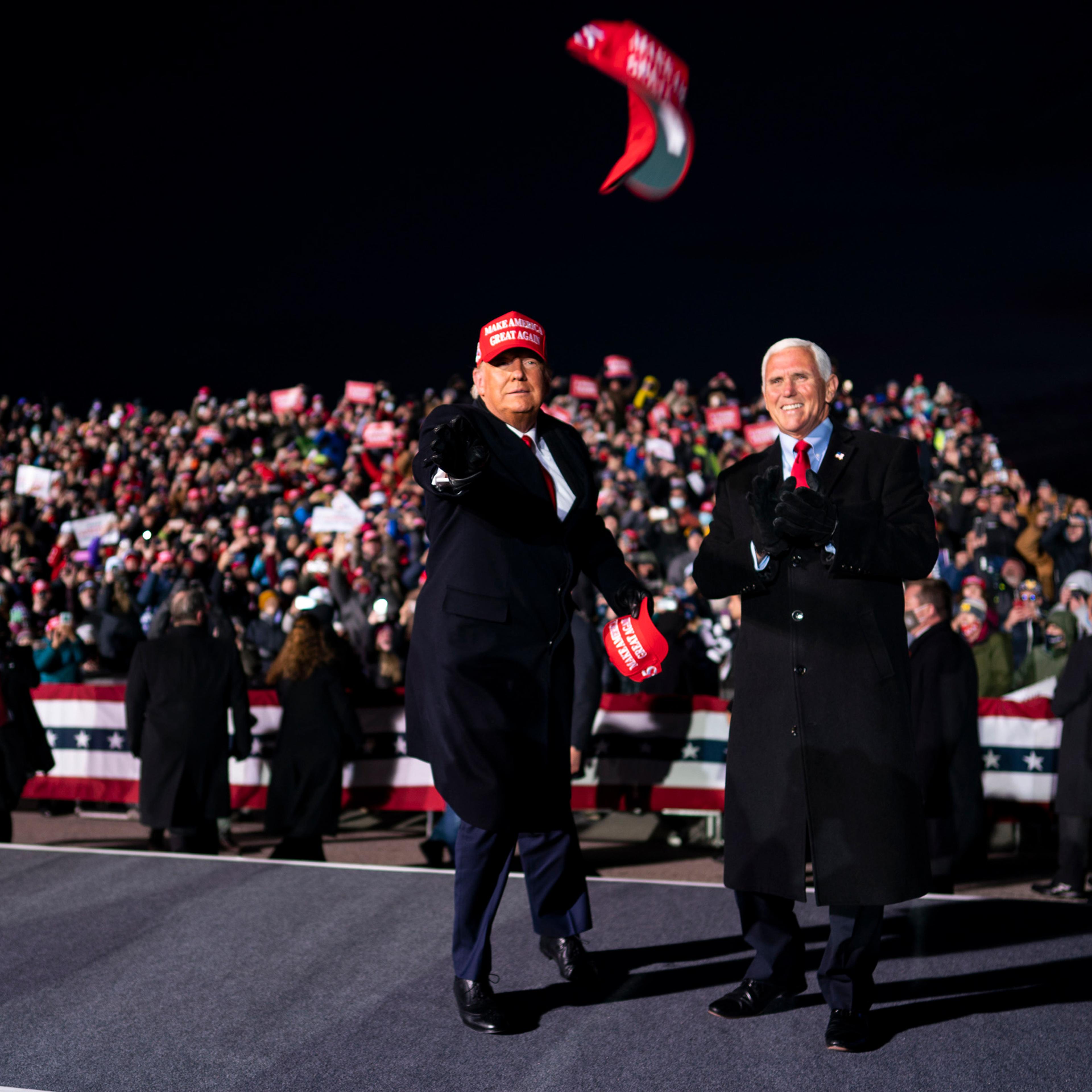 President Donald Trump tosses campaign hats to the audience during a campaign rally with Vice President Mike Pence at Cherry Capital Airport in Traverse City, Mich., Monday, Nov, 2, 2020. (Doug Mills/The New York Times)