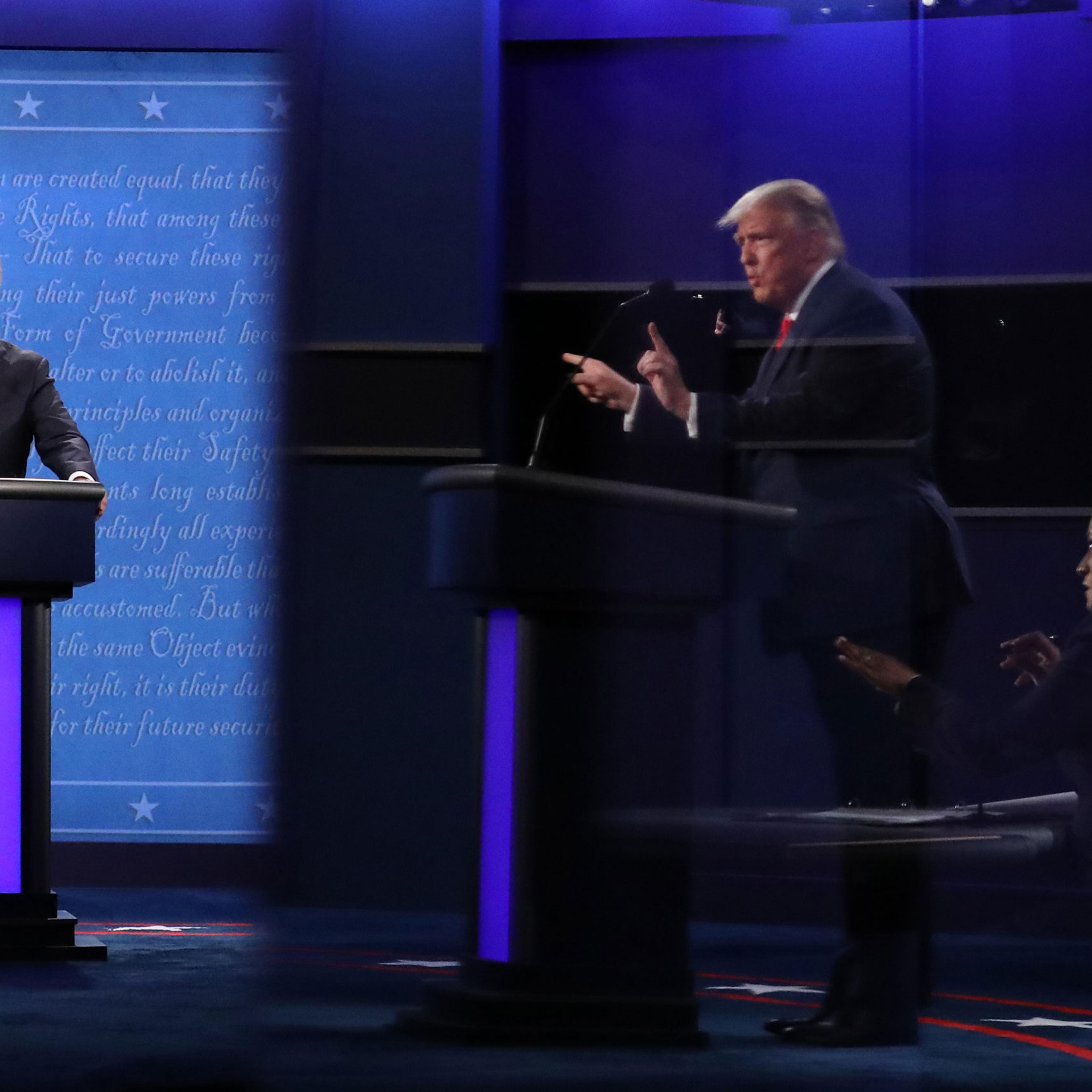 President Donald Trump and Moderator Kristen Welker, seen in a reflection, and Democratic presidential nominee Joe Biden participate in the final presidential debate in Nashville, on Oct. 22, 2020.
