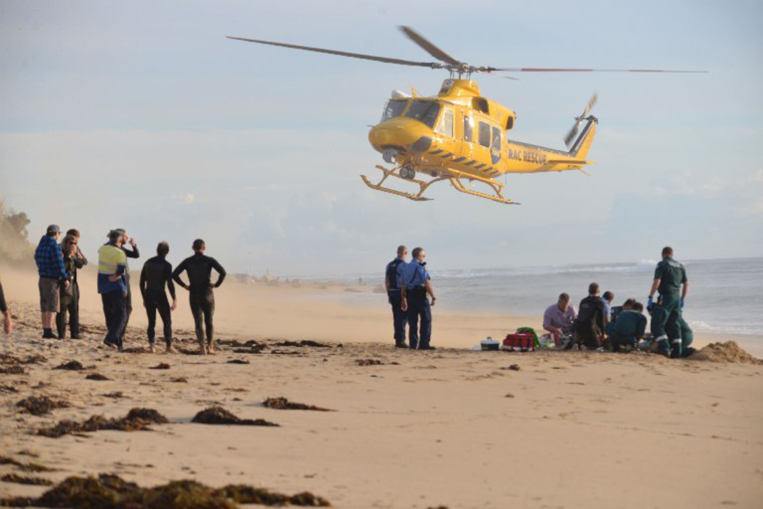 A photo taken on 31 May, 2016, shows a rescue helicopter arriving to transport a critically injured surfer after a shark ripped off his leg in an attack in Australia's west with witnesses recounting how "all hell broke loose" as his board was snapped in 