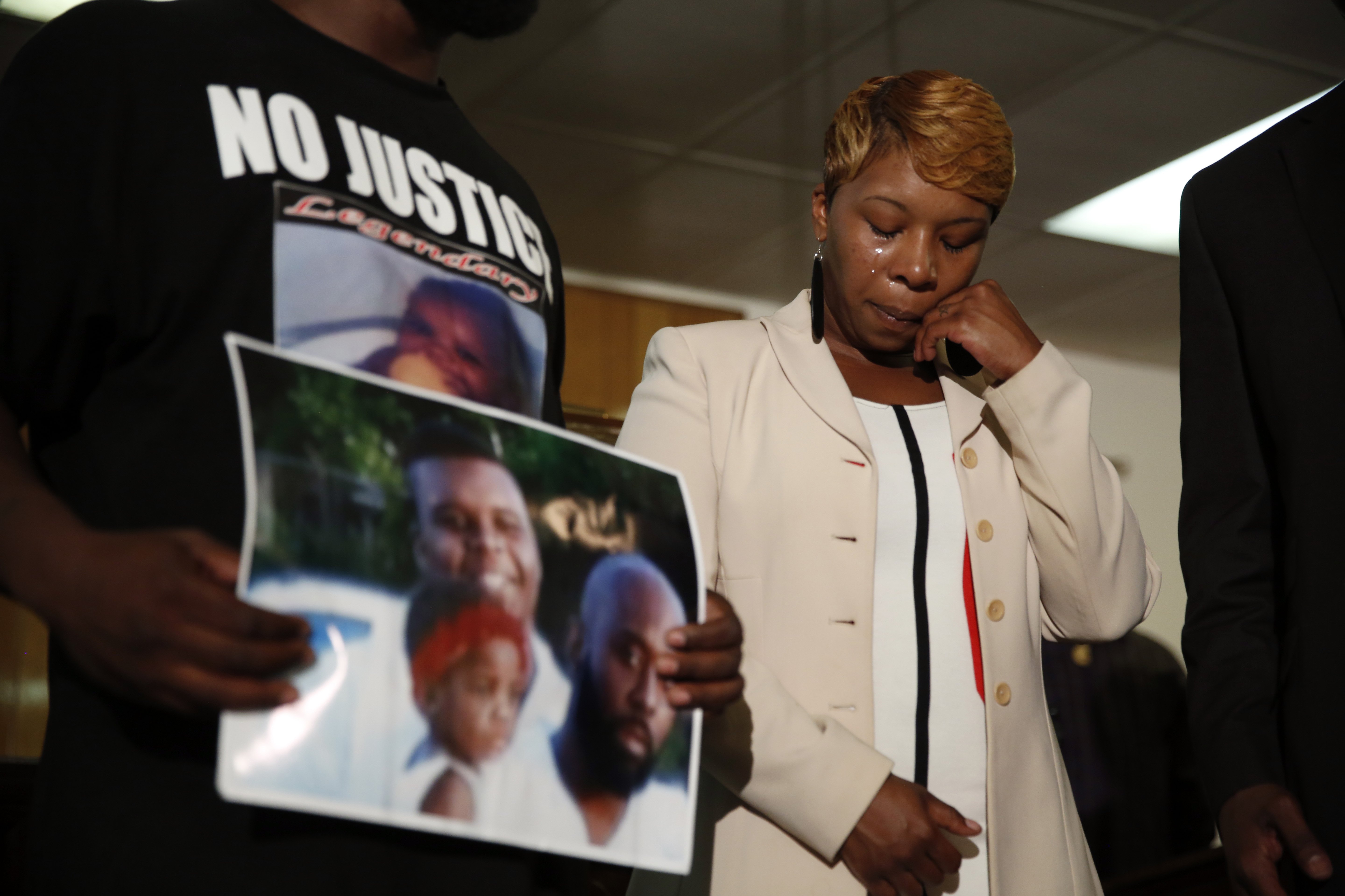Lesley McSpadden, the mother of 18-year-old Michael Brown, wipes away tears as Brown's father, Michael Brown Sr., holds up a family picture of himself and his son during a news conference on August 11, 2014, in Ferguson, Mo.