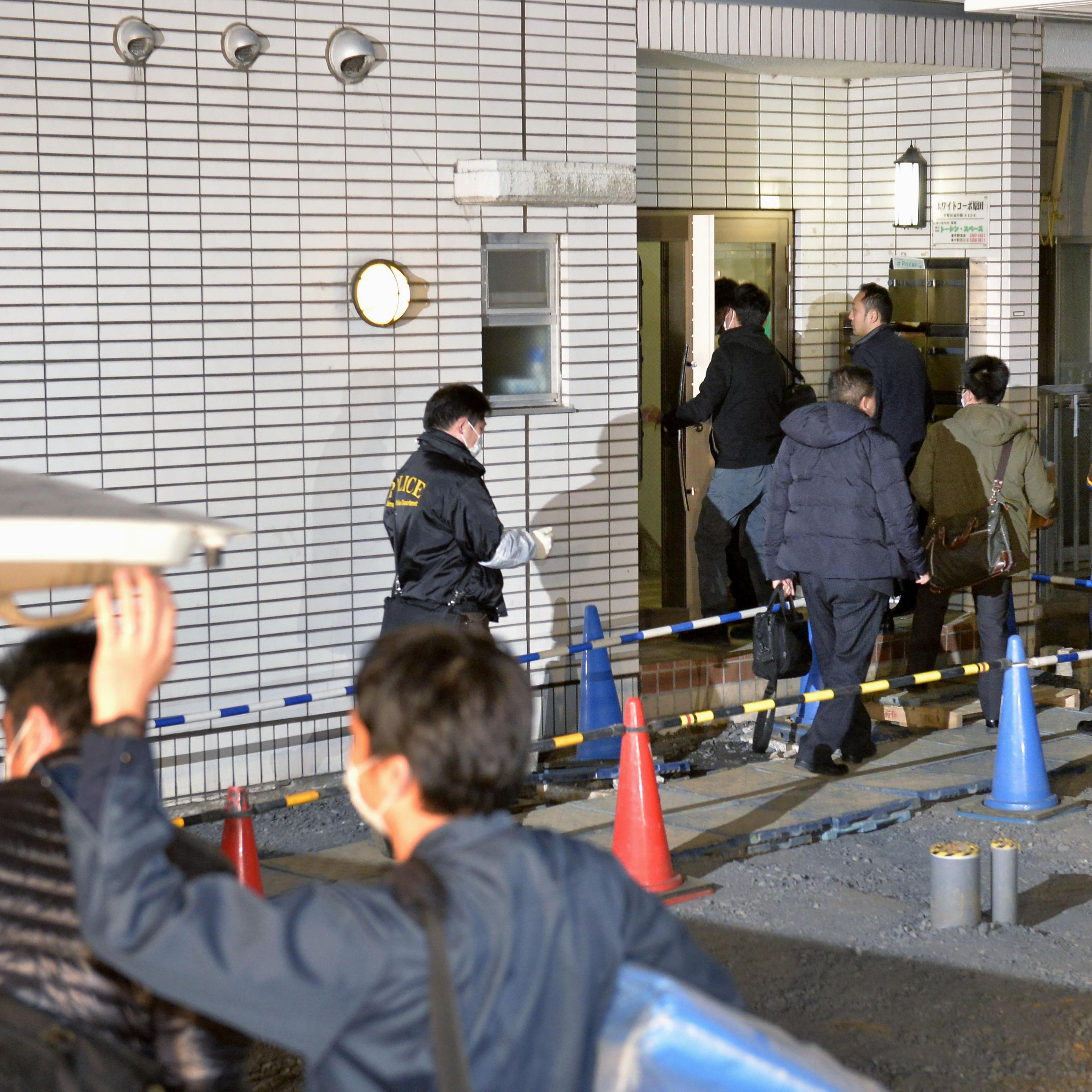 Police officers arrive for investigation of the apartment of abduction suspect Kabu Terauchi in Tokyo on March 28, 2016.