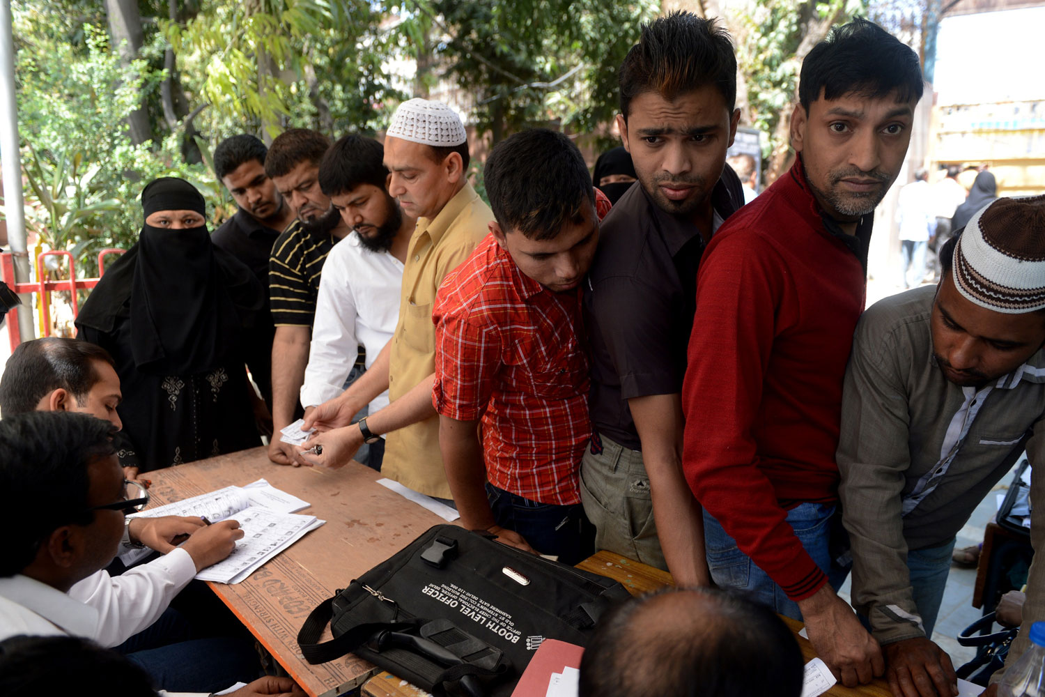 Indian polling officials check the details of voters at a polling station in New Delhi on April 10, 2014.
