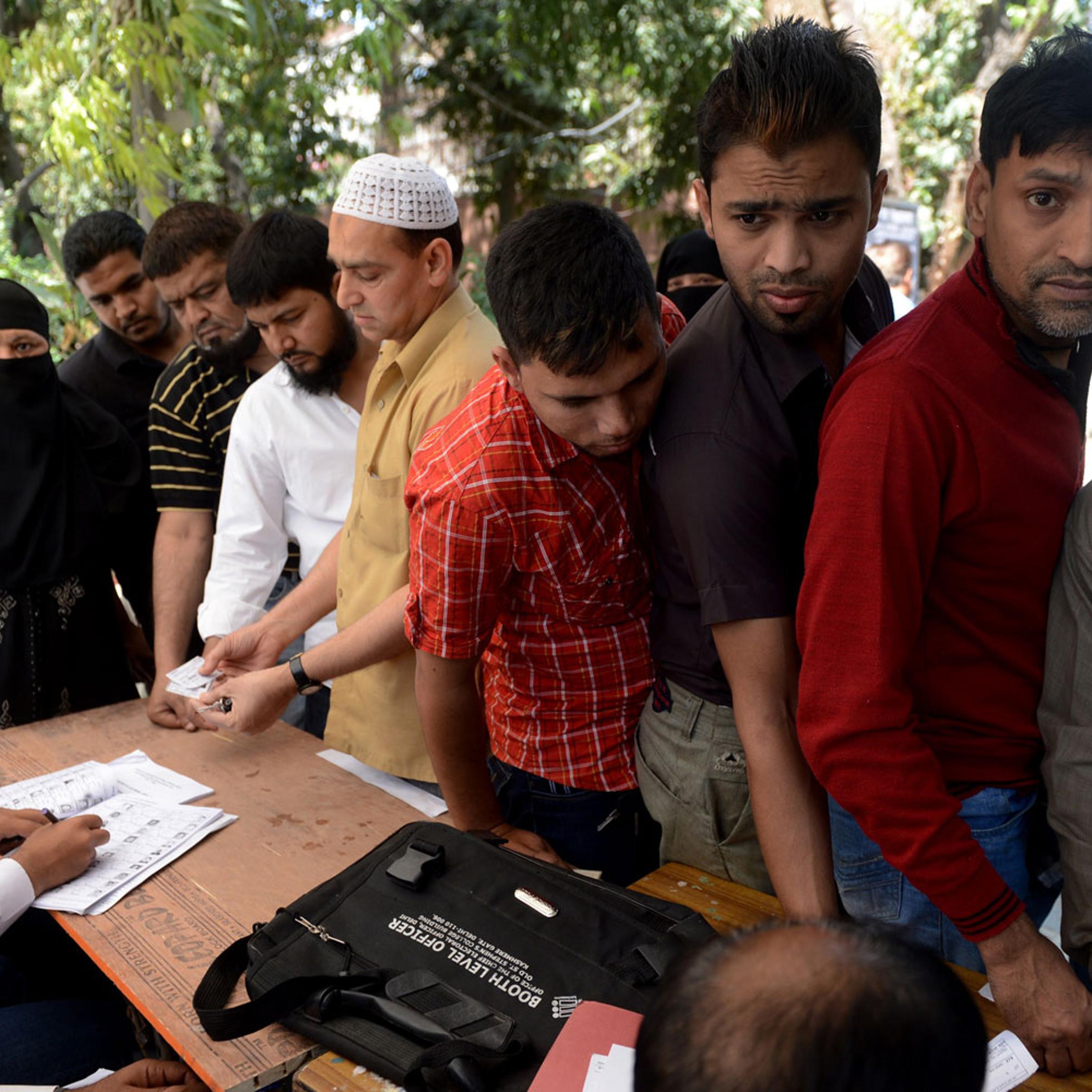 Indian polling officials check the details of voters at a polling station in New Delhi on April 10, 2014.