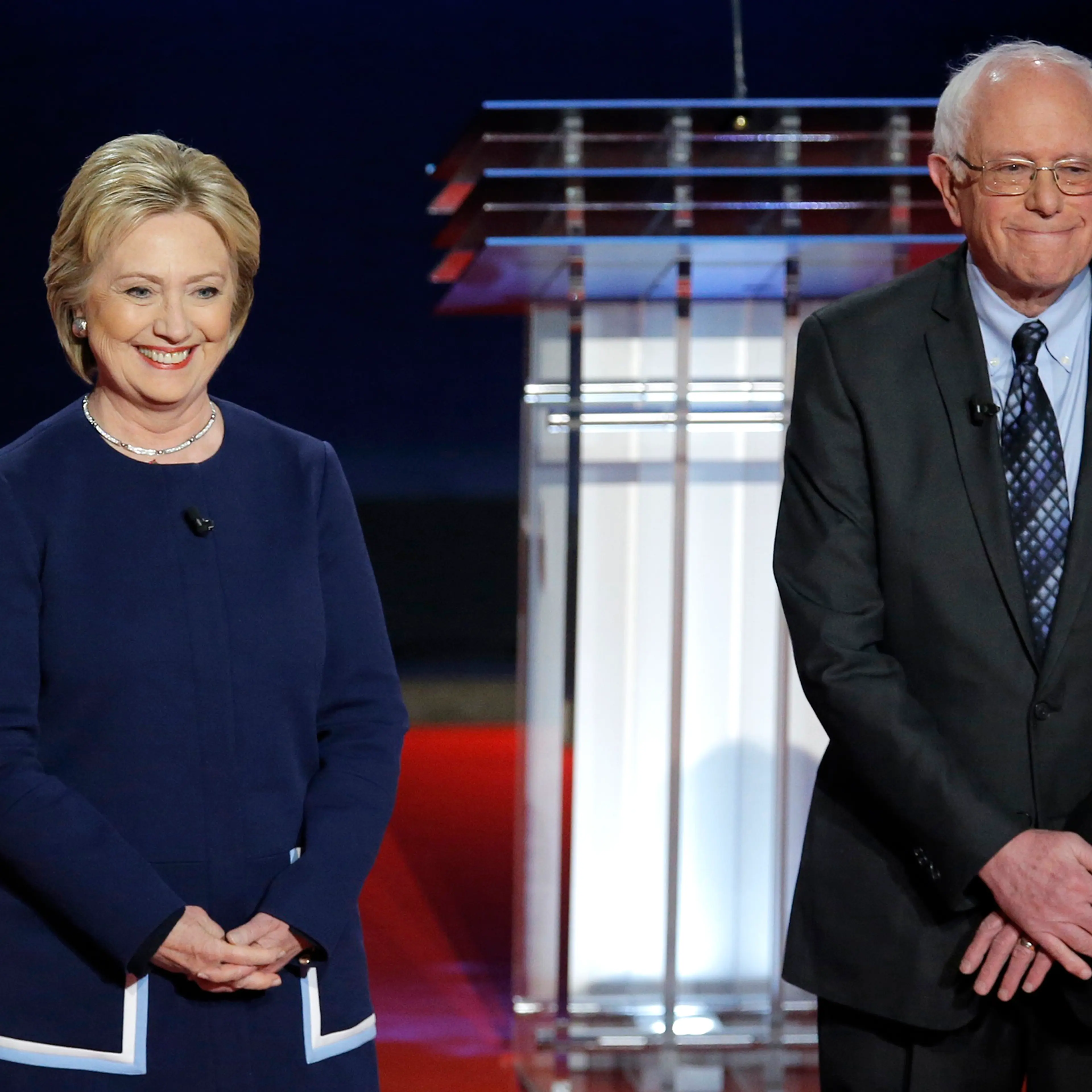 Hillary Clinton and Bernie Sanders pose together onstage at the start of the U.S. Democratic presidential candidates' debate in Flint, Michi. on March 6, 2016.