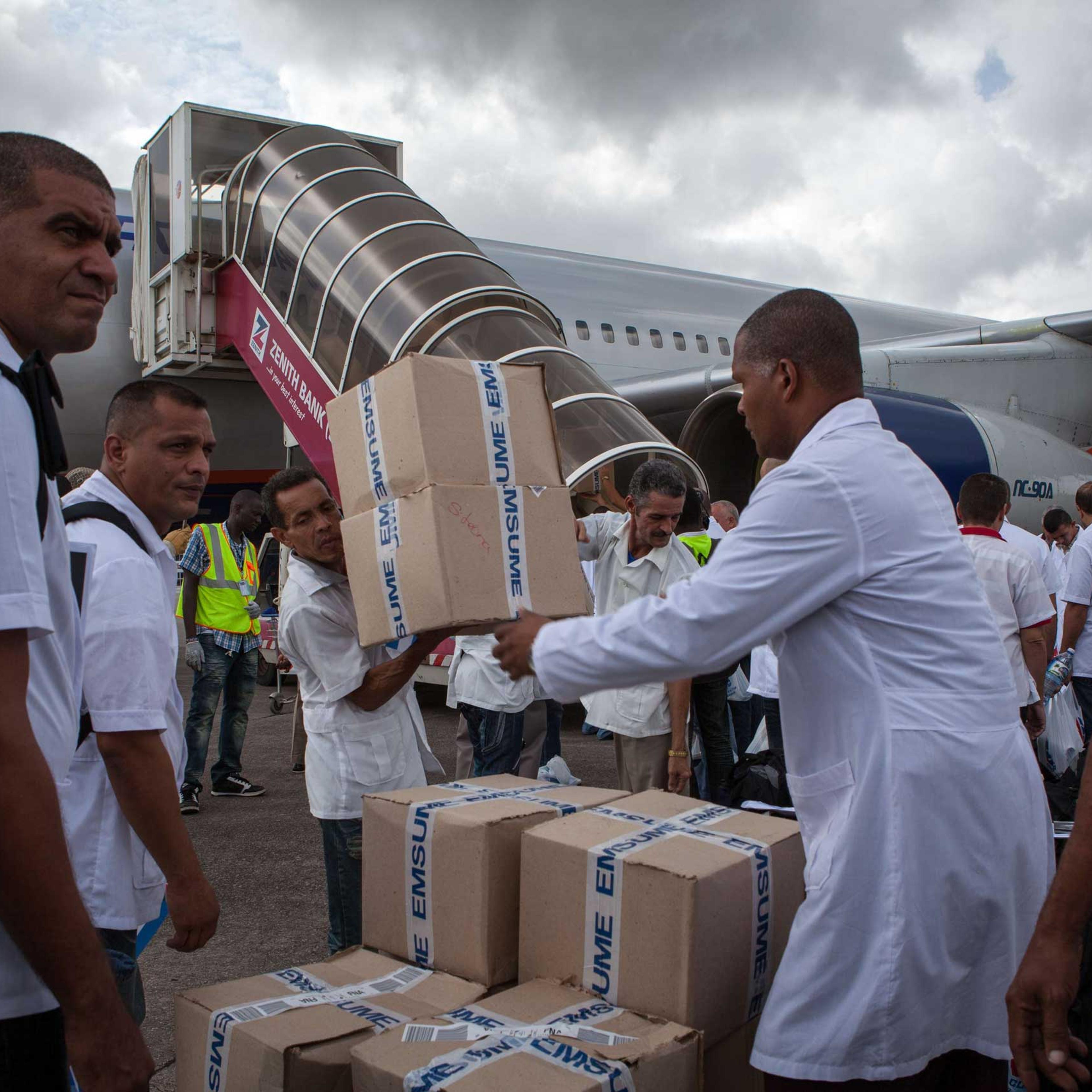 Cuban doctors and health workers unload boxes of medicines and medical material from a plane upon their arrival at Freetown's airport to help the fight against Ebola in Sierra Leone, on Oct. 2, 2014.