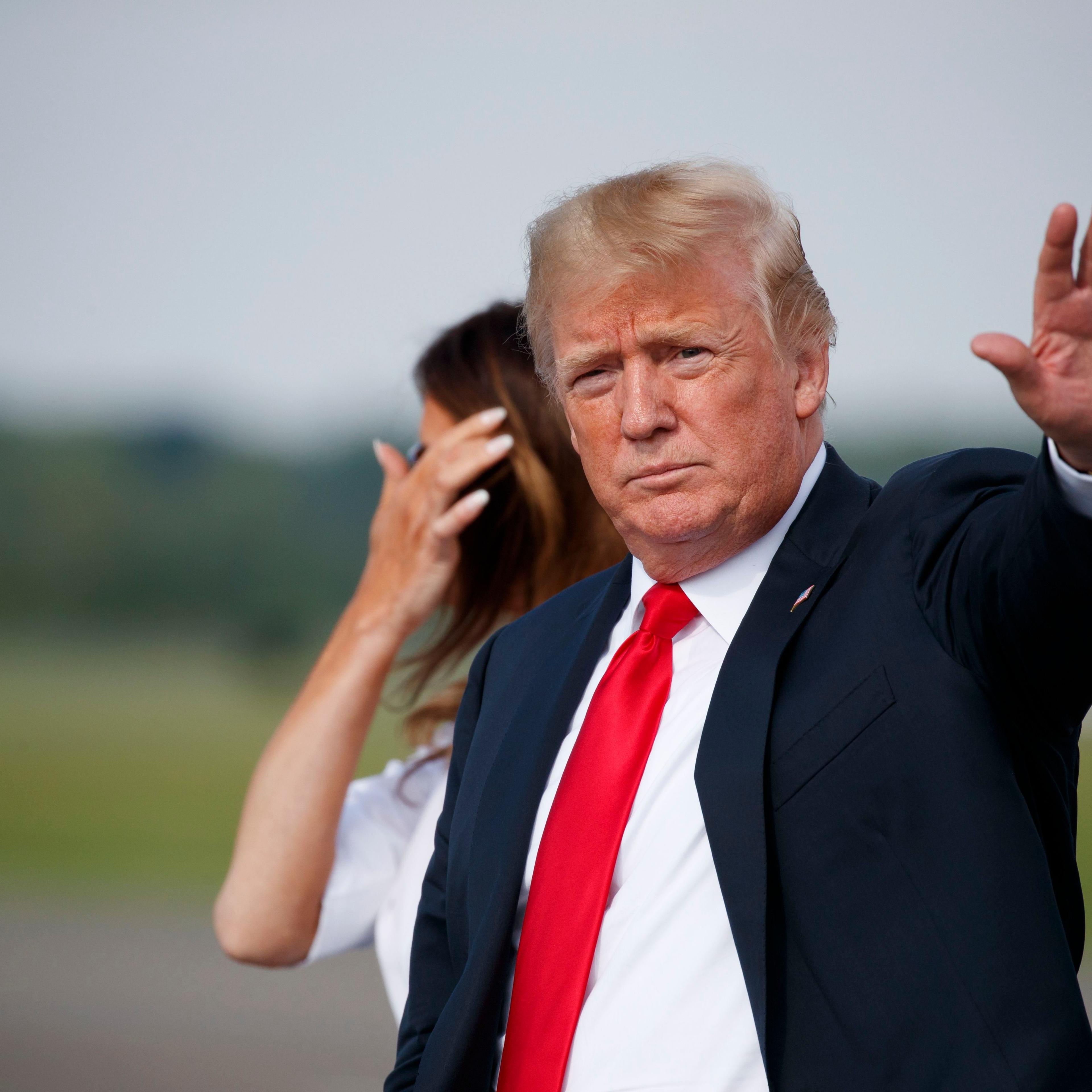 Trump waves to the press after getting off Air Force One