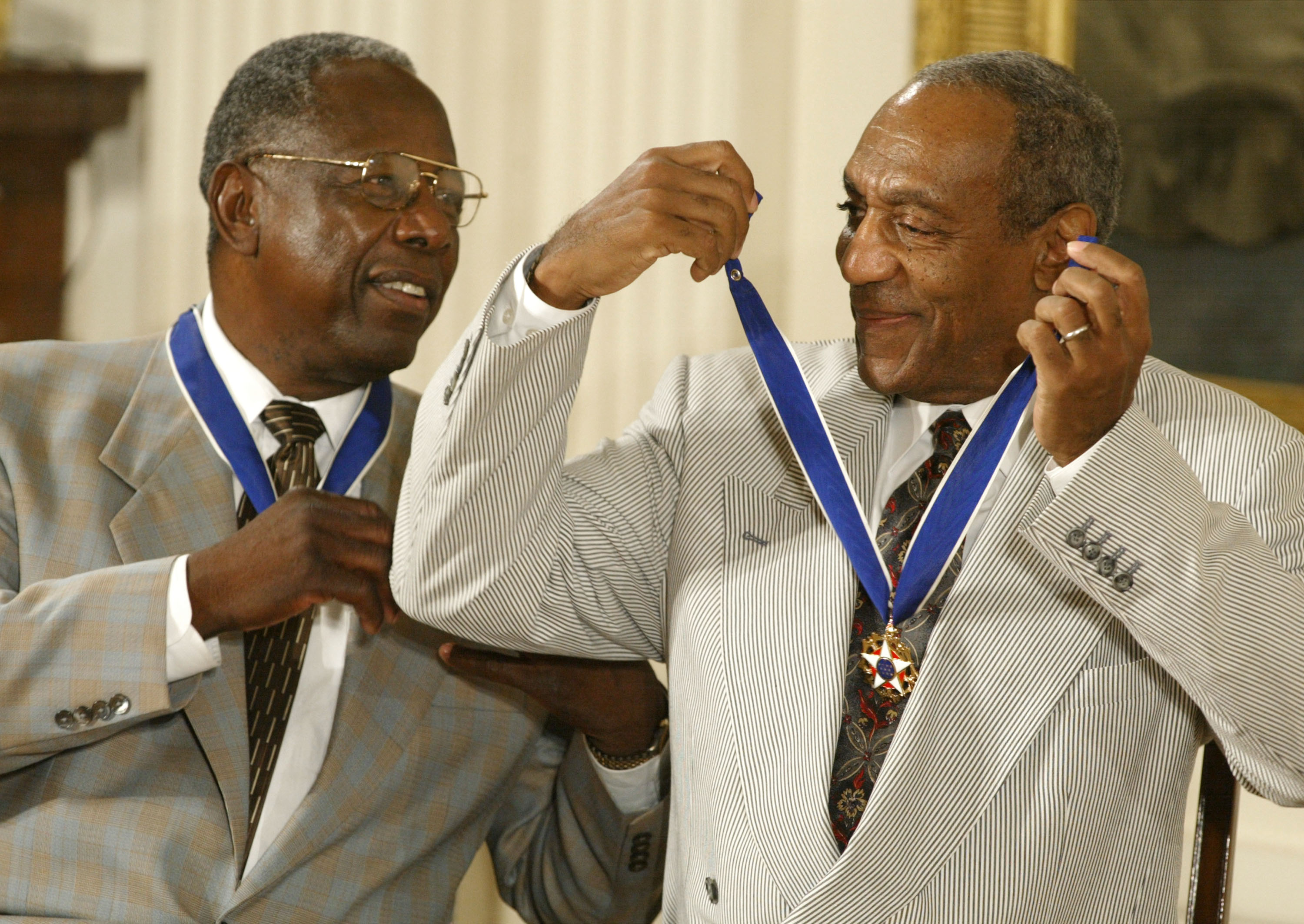 Actor Comedian Bill Cosby jokes with baseball great Hank Aaron after they both received the Presidential Medal of Freedom Award from President George W. Bush during a ceremony on July 9, 2002 at the White House in Washington.