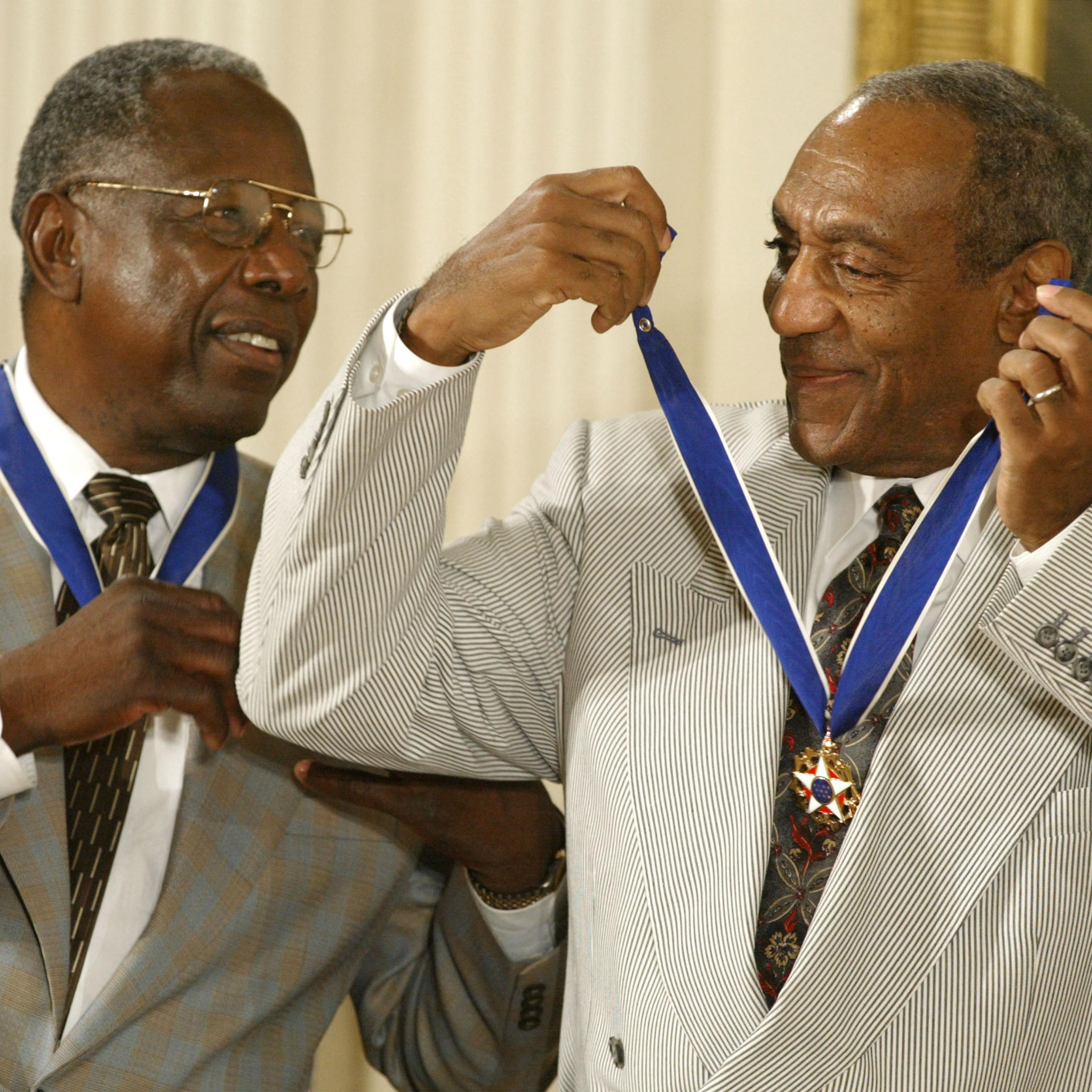 Actor Comedian Bill Cosby jokes with baseball great Hank Aaron after they both received the Presidential Medal of Freedom Award from President George W. Bush during a ceremony on July 9, 2002 at the White House in Washington.