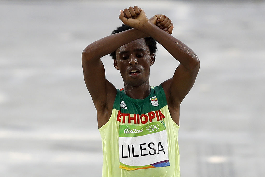 Ethiopia's Feyisa Lilesa (silver) crosses the finish line of the Men's Marathon athletics event during the Rio 2016 Olympic Games at the Sambodromo in Rio de Janeiro on August 21, 2016. Lilesa crossed his arms above his head as he finished the race as a 