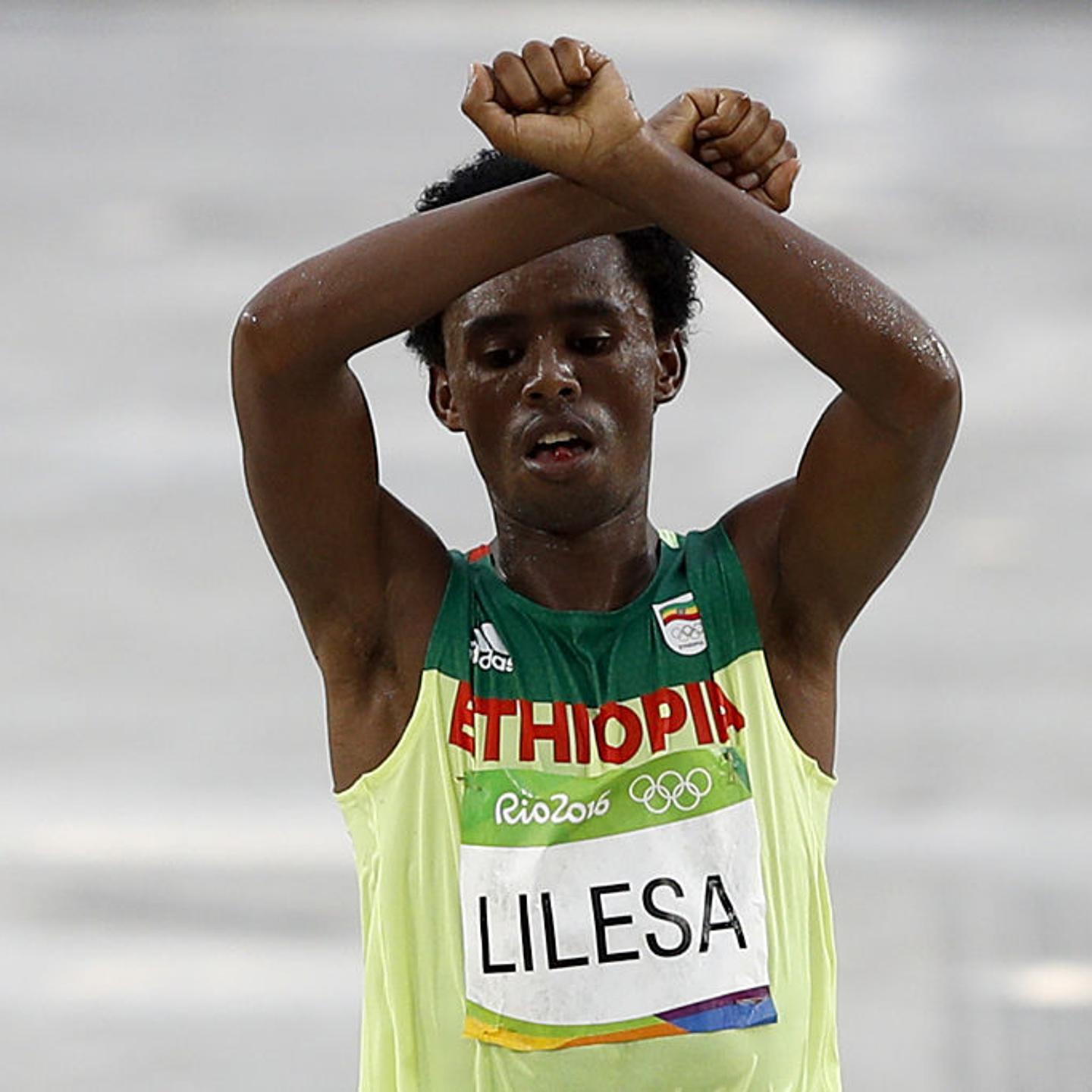 Ethiopia's Feyisa Lilesa (silver) crosses the finish line of the Men's Marathon athletics event during the Rio 2016 Olympic Games at the Sambodromo in Rio de Janeiro on August 21, 2016. Lilesa crossed his arms above his head as he finished the race as a