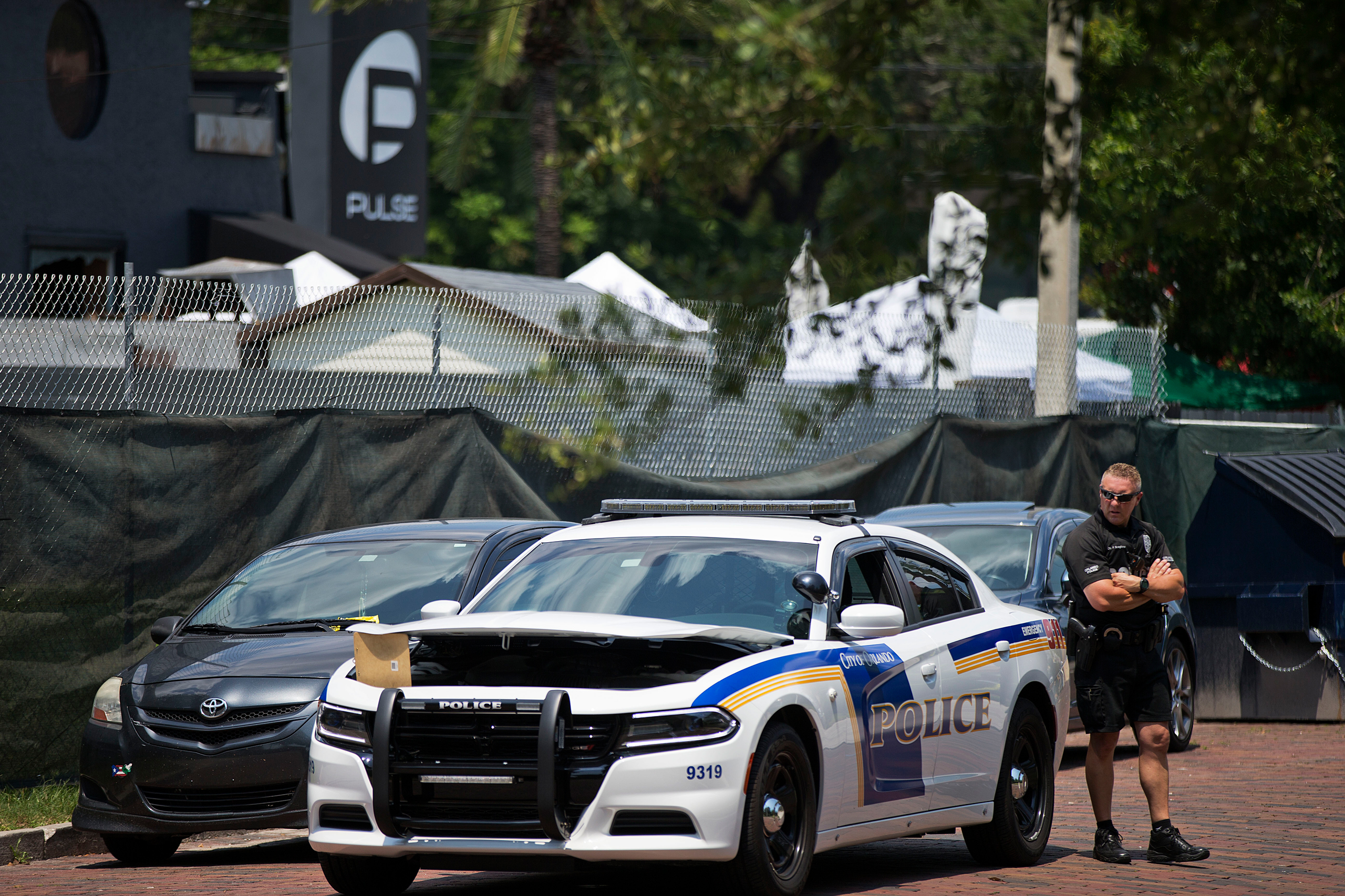 A police officer stands guard next to the scene of a mass shooting at the Pulse nightclub, Monday, June 13, 2016, in Orlando, Fla. (AP Photo/David Goldman)