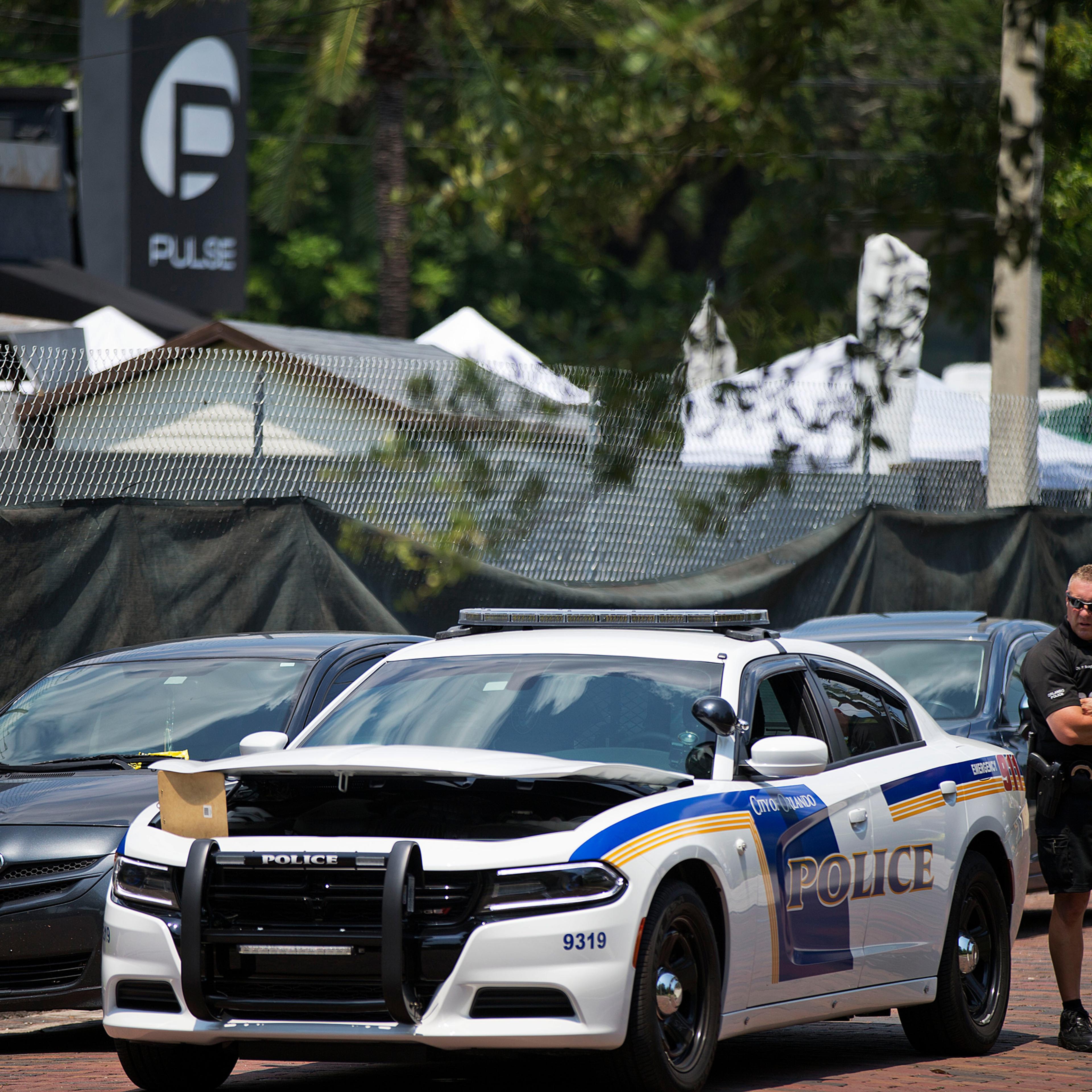 A police officer stands guard next to the scene of a mass shooting at the Pulse nightclub, Monday, June 13, 2016, in Orlando, Fla. (AP Photo/David Goldman)