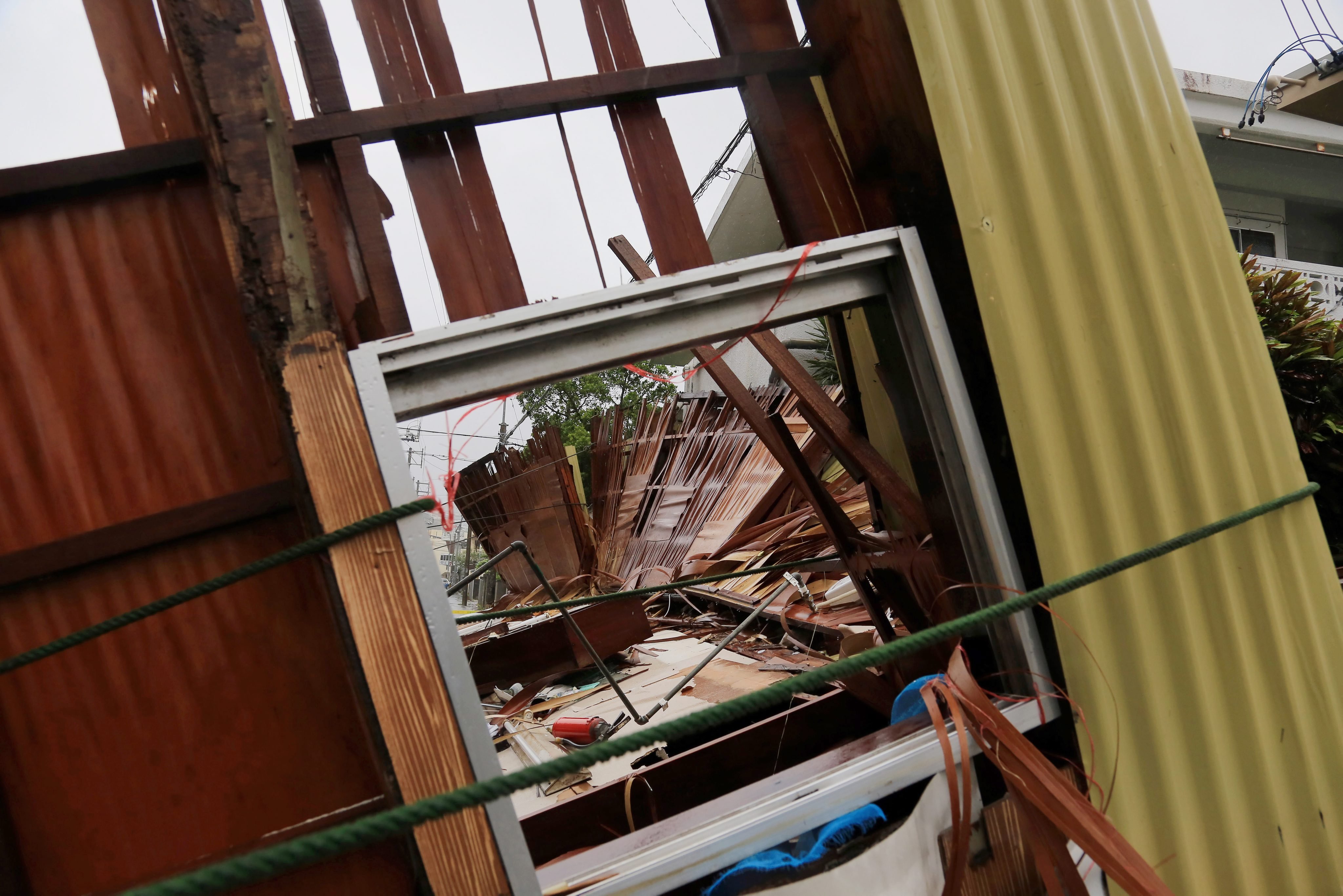 A wooden house hosting a restaurant lies on a street after it collapsed due to the strong generated by typhoon Neoguri in Matsugawa district of Naha city, on the island of Okinawa, southern Japan on July 8, 2014.