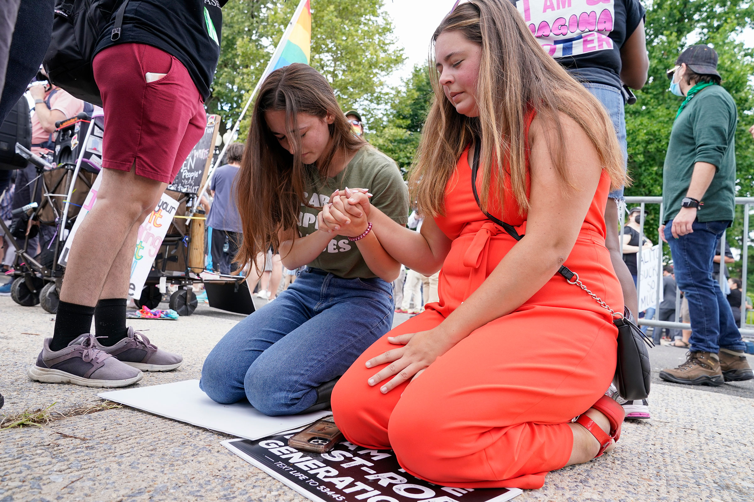 Anti-abortion activists Maggie Donica, 21, right, and Grace Rykaczewski, 21, left, pray following the Supreme Court's decision to overturn Roe v. Wade, federally protected right to abortion, in Washington, Friday, June 24, 2022. 