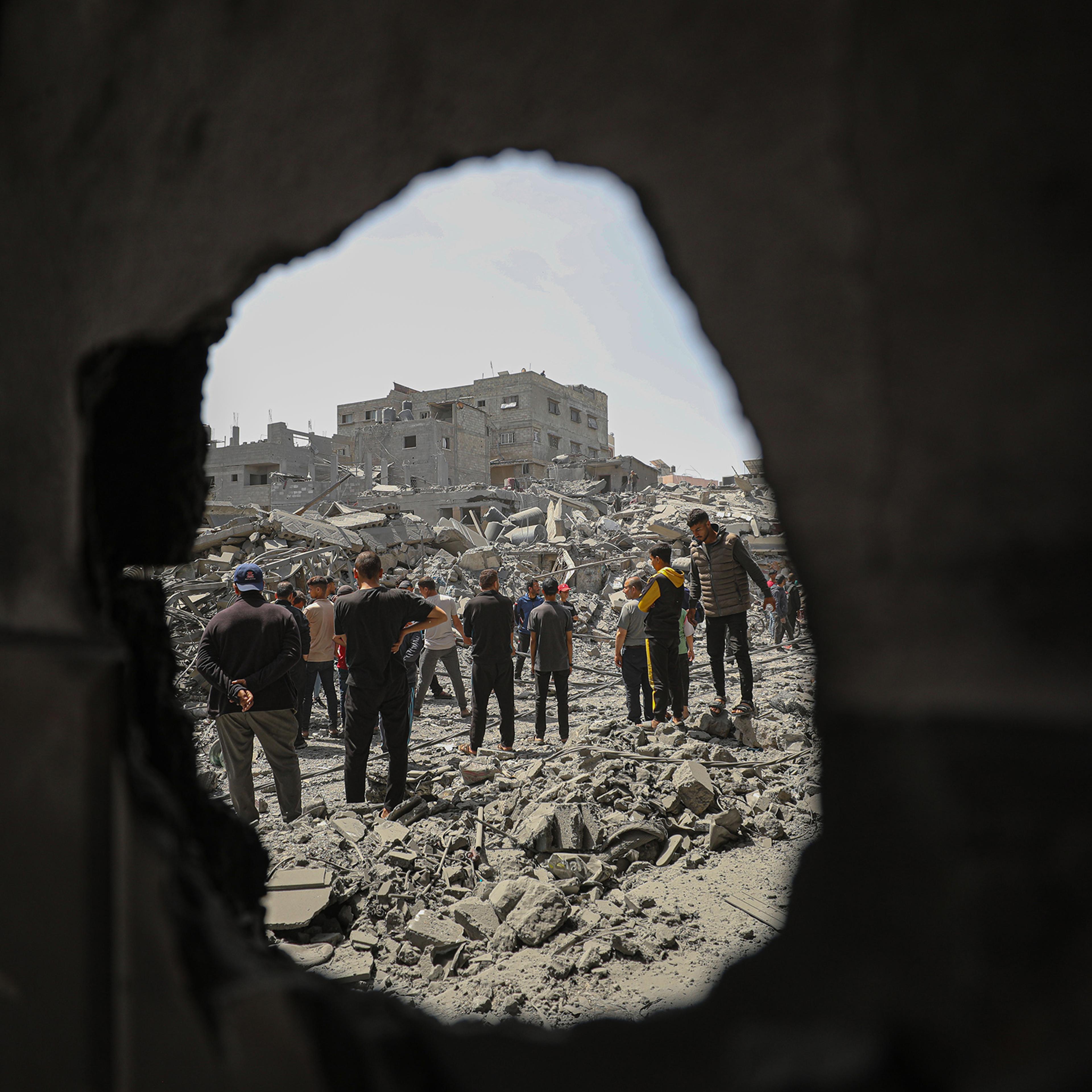 People look at damaged buildings and vehicles after an Israeli attack, in Gaza City, April 22, 2024.