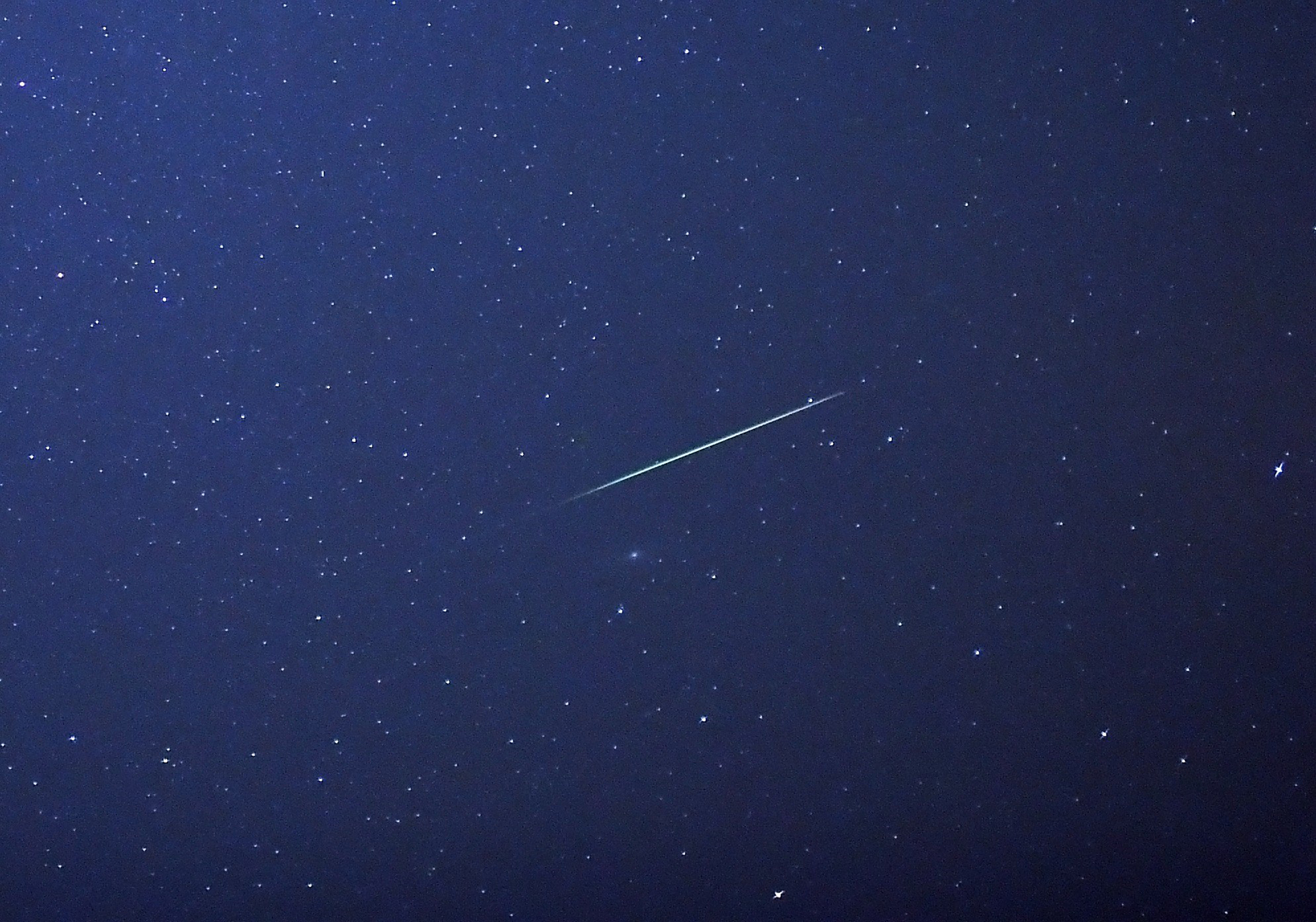 A falling star crosses the night sky over Halle / Saale, eastern Germany, during the peak in activity of the annual Perseids meteor shower on August 13, 2015. The Perseids meteor shower occurs every year when the Earth passes through the cloud of debris 