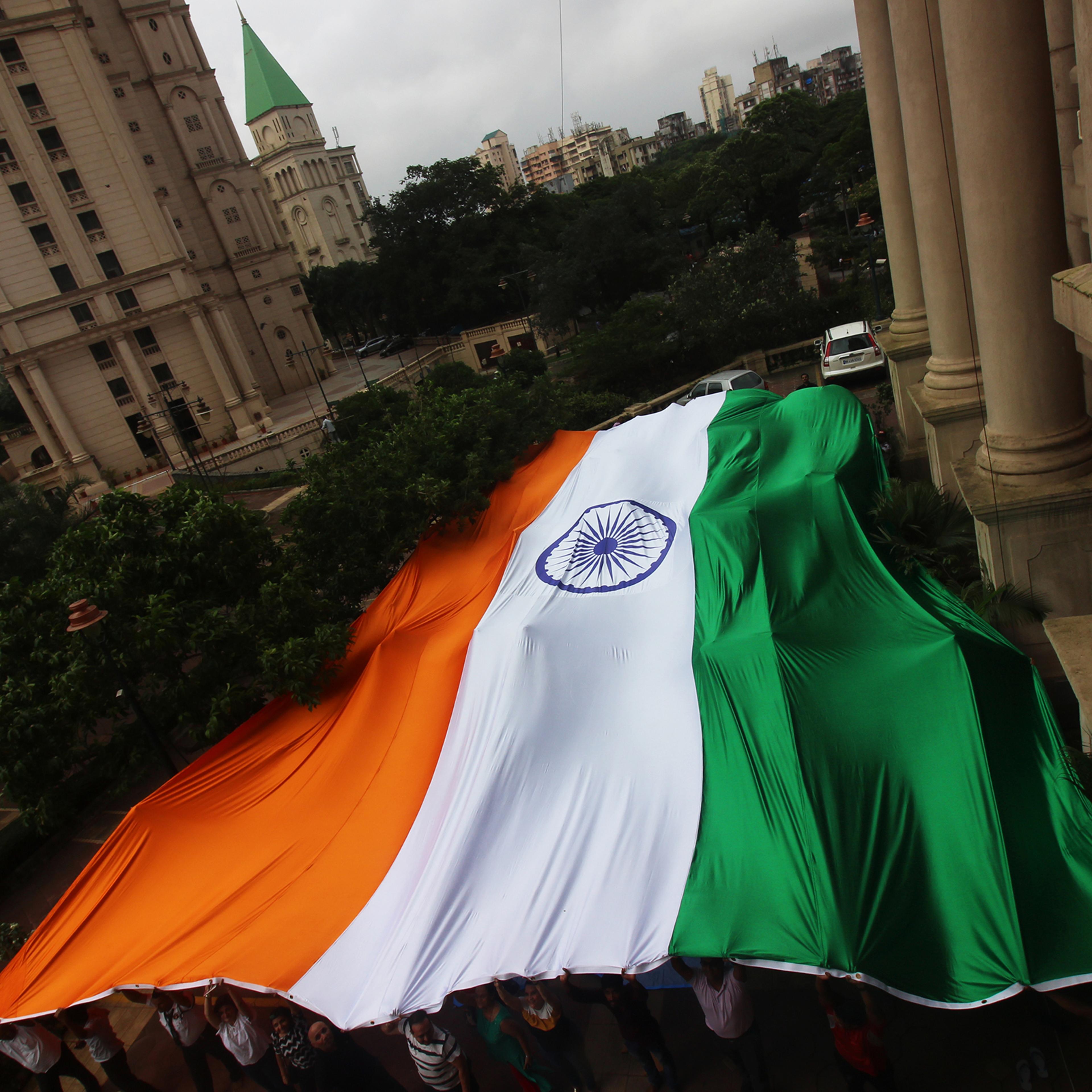 People hold a giant Indian national flag ahead of the 73rd Independence Day celebrations in Mumbai in August 2019.
