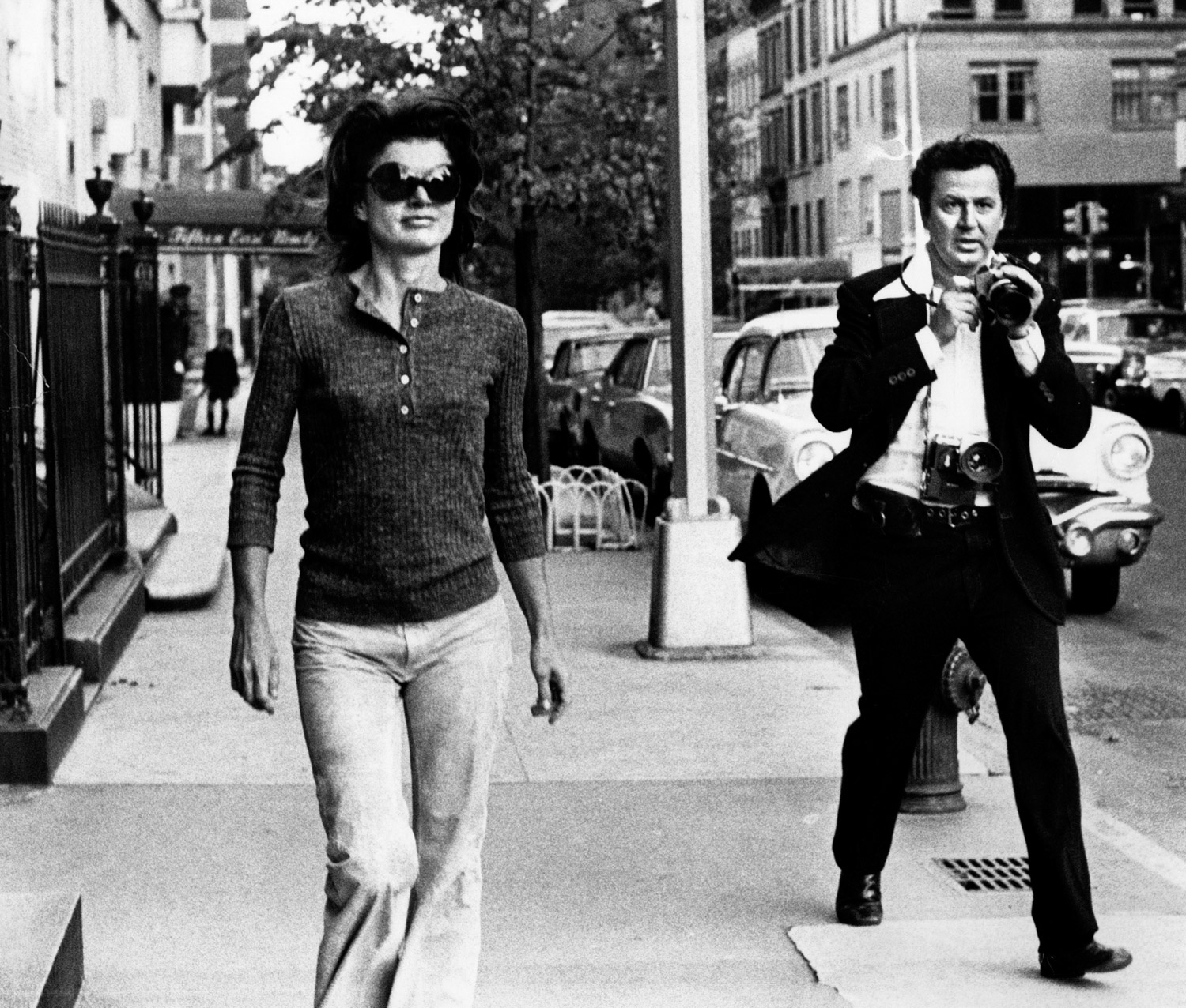 Jacqueline Kennedy Onassis is pursued by paparazzi photographer Ron Galella on the streets of New York City.