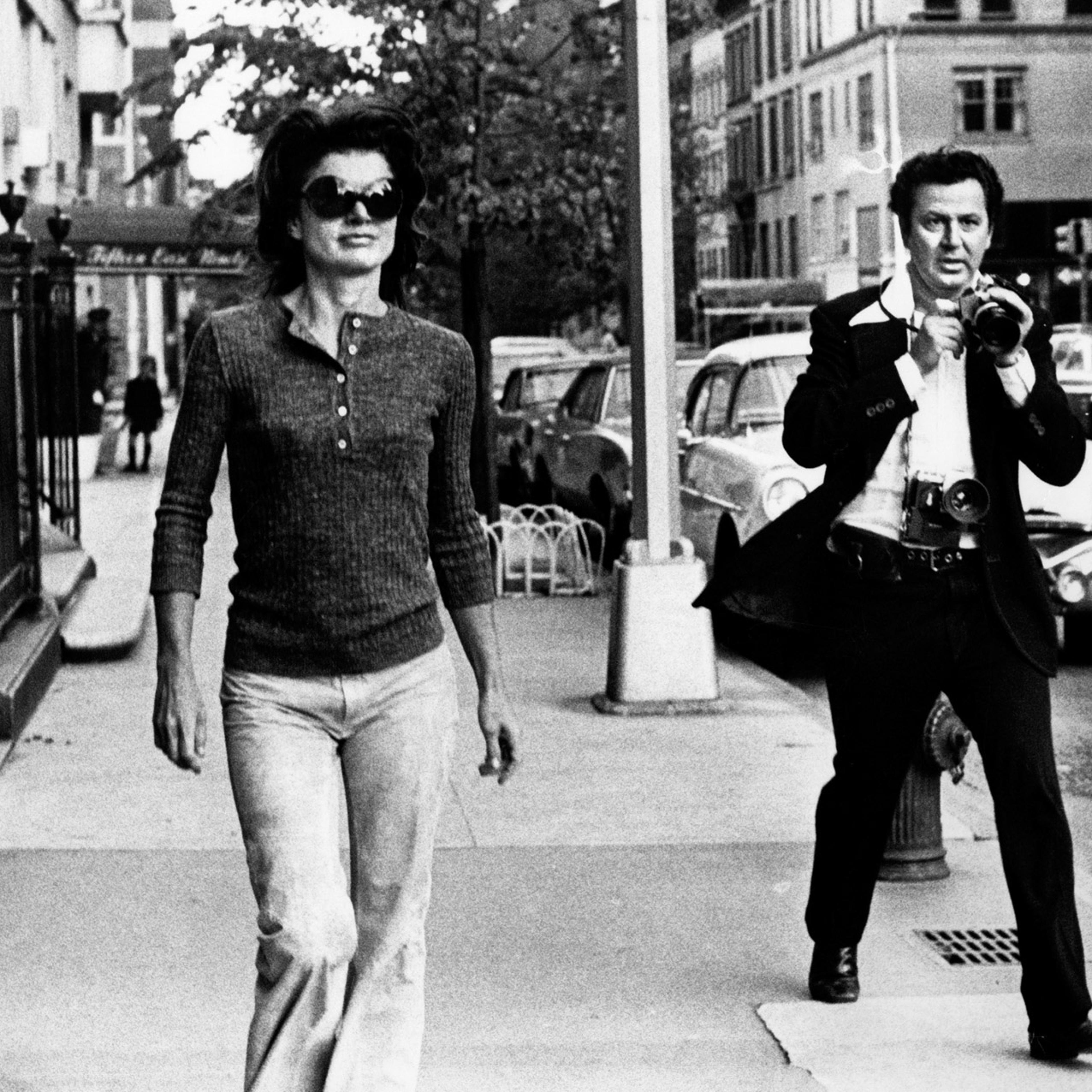Jacqueline Kennedy Onassis is pursued by paparazzi photographer Ron Galella on the streets of New York City.