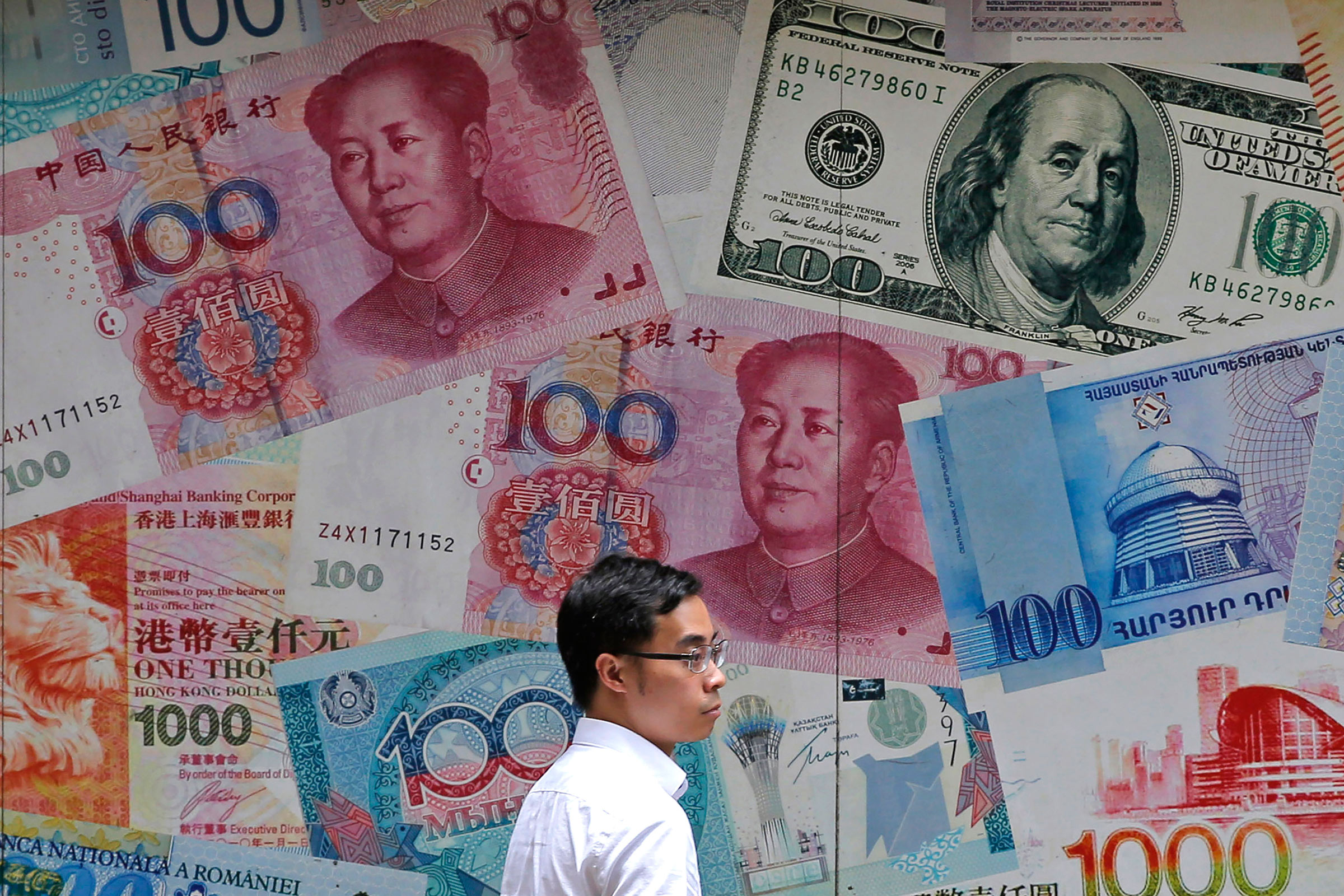 A man walks past a money exchange shop decorated with different banknotes at Central, a business district of Hong Kong on June 10.