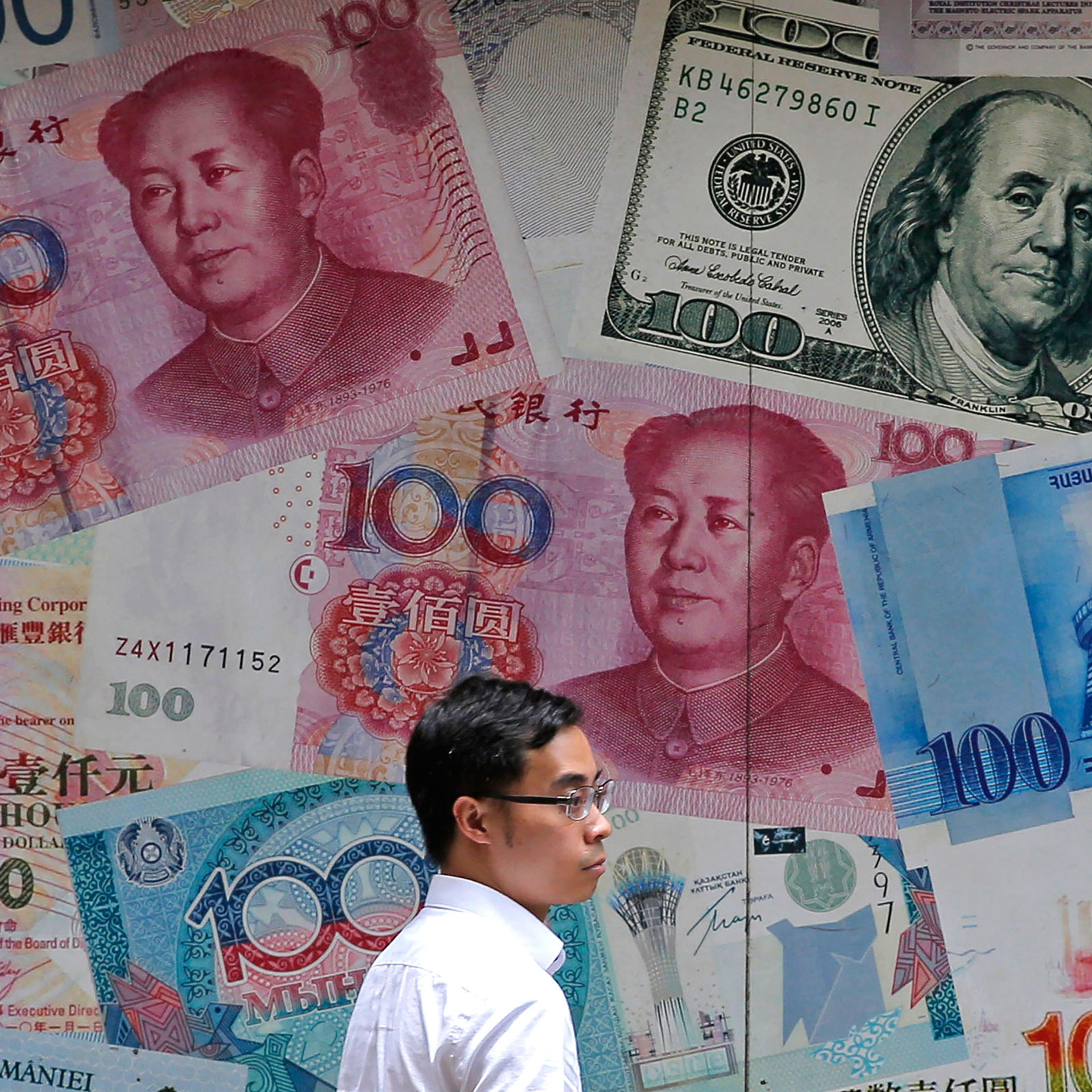 A man walks past a money exchange shop decorated with different banknotes at Central, a business district of Hong Kong on June 10.
