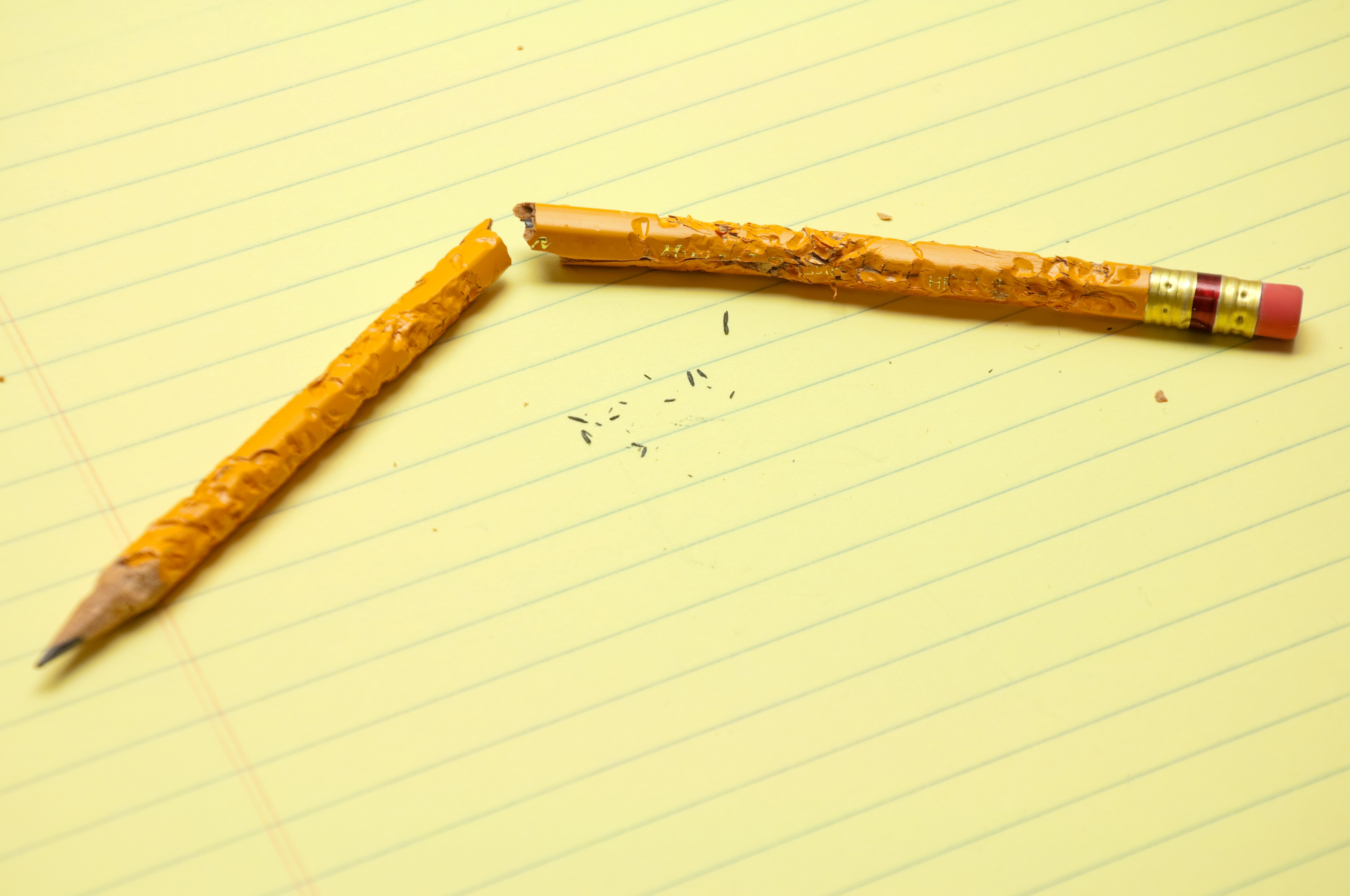 Broken Chewed Pencil On Notepad